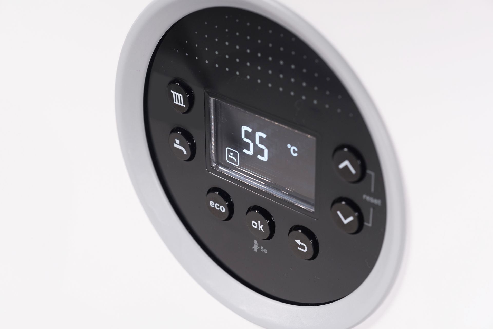 A close up of a thermostat showing 55 degrees celsius