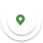 A green map pin icon centered on a white circular background with a subtle shadow.