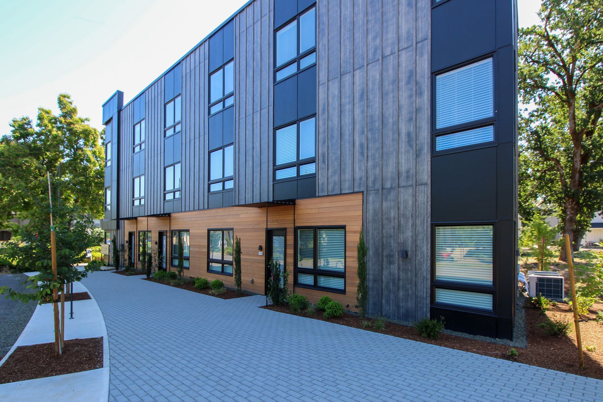A large building with a lot of windows and trees in front of it.