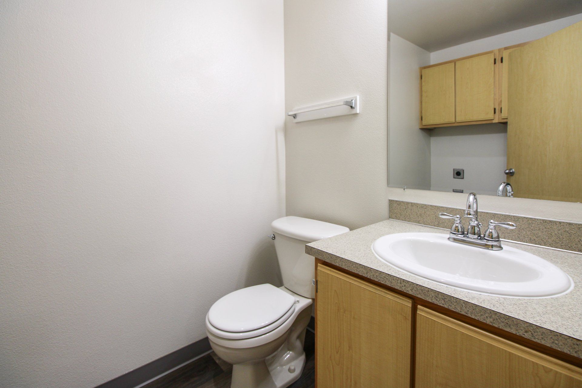 A bathroom with a toilet , sink and mirror