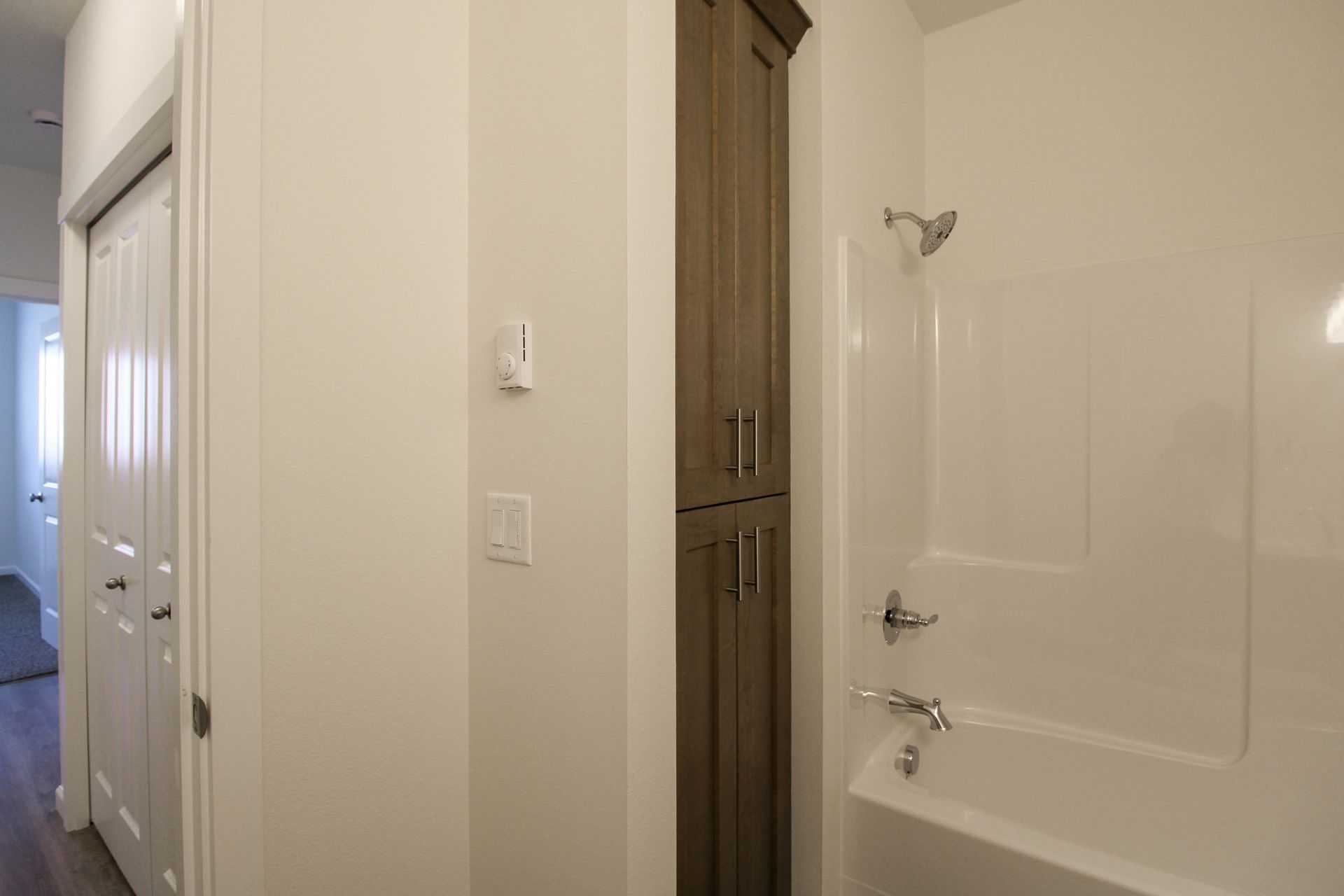 A bathroom with a tub , shower and cabinets.