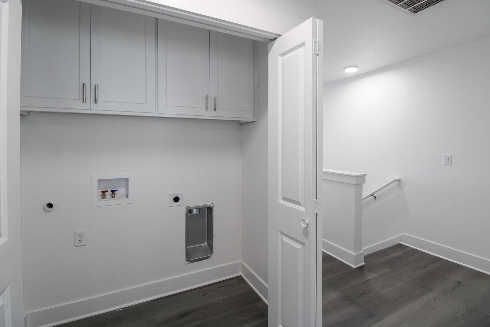 A laundry room with a staircase leading up to the second floor.