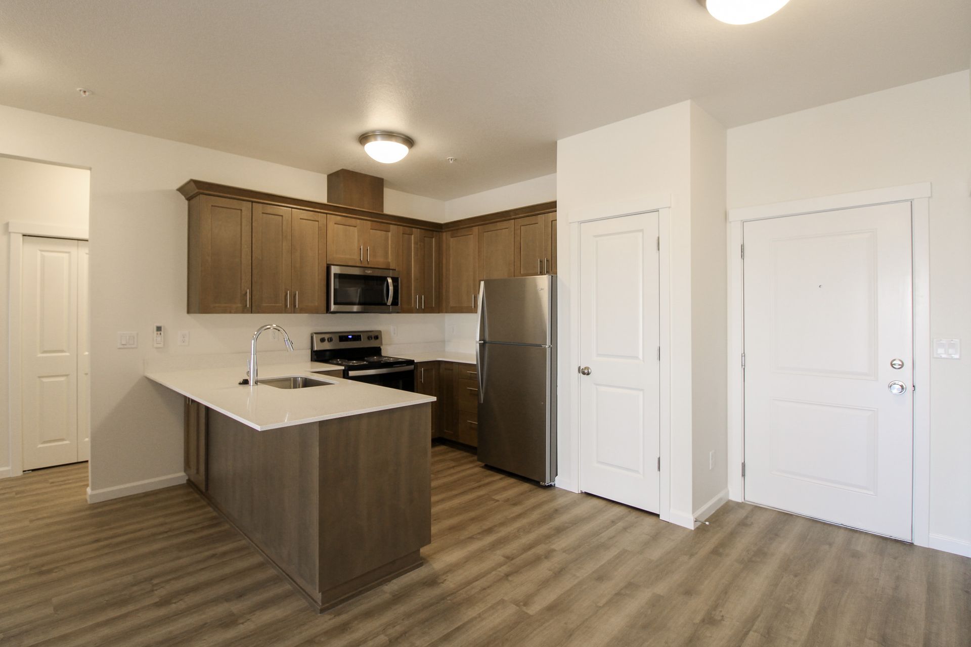 A kitchen with wooden cabinets , stainless steel appliances , and a large island.