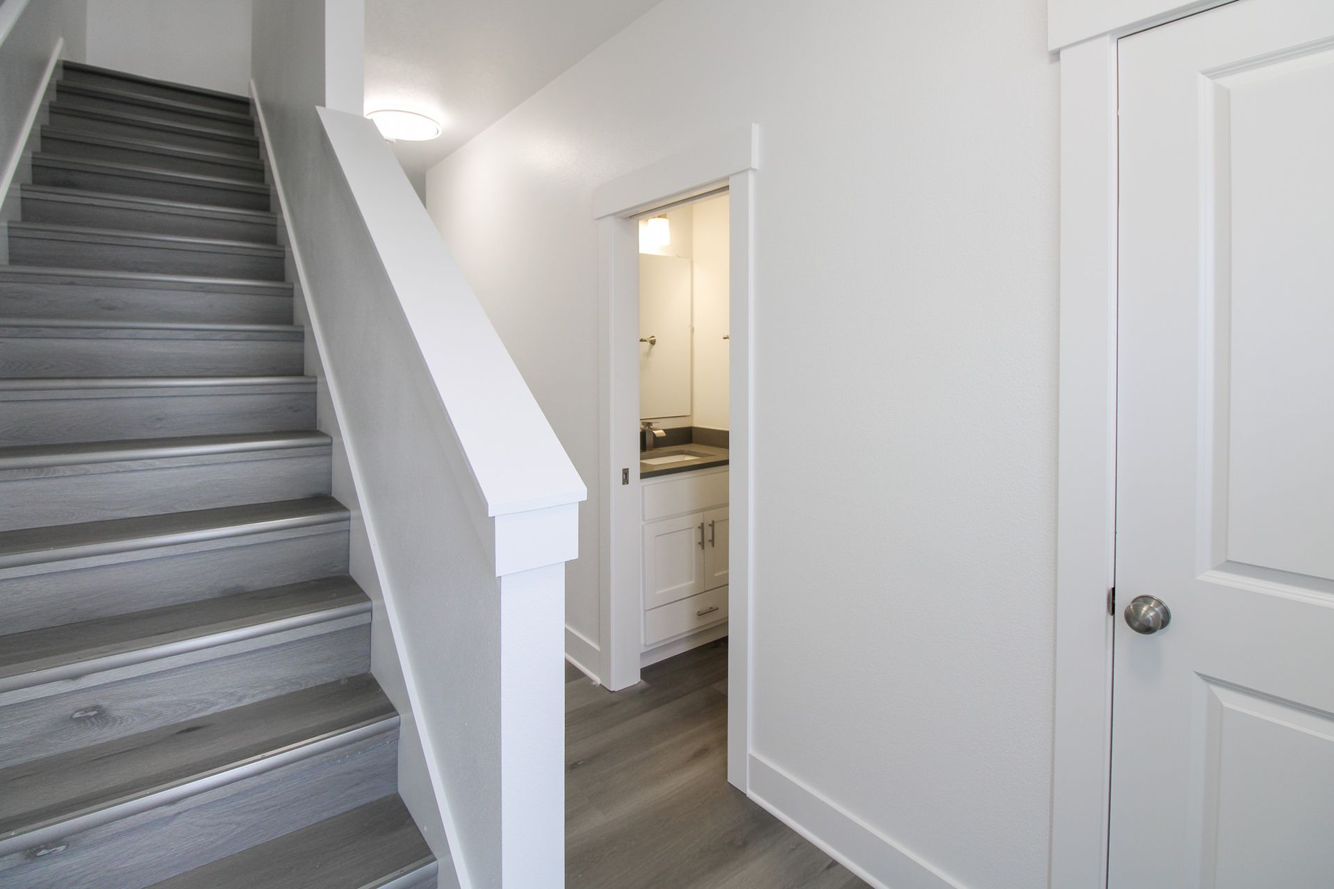 A hallway with stairs leading up to a bathroom.