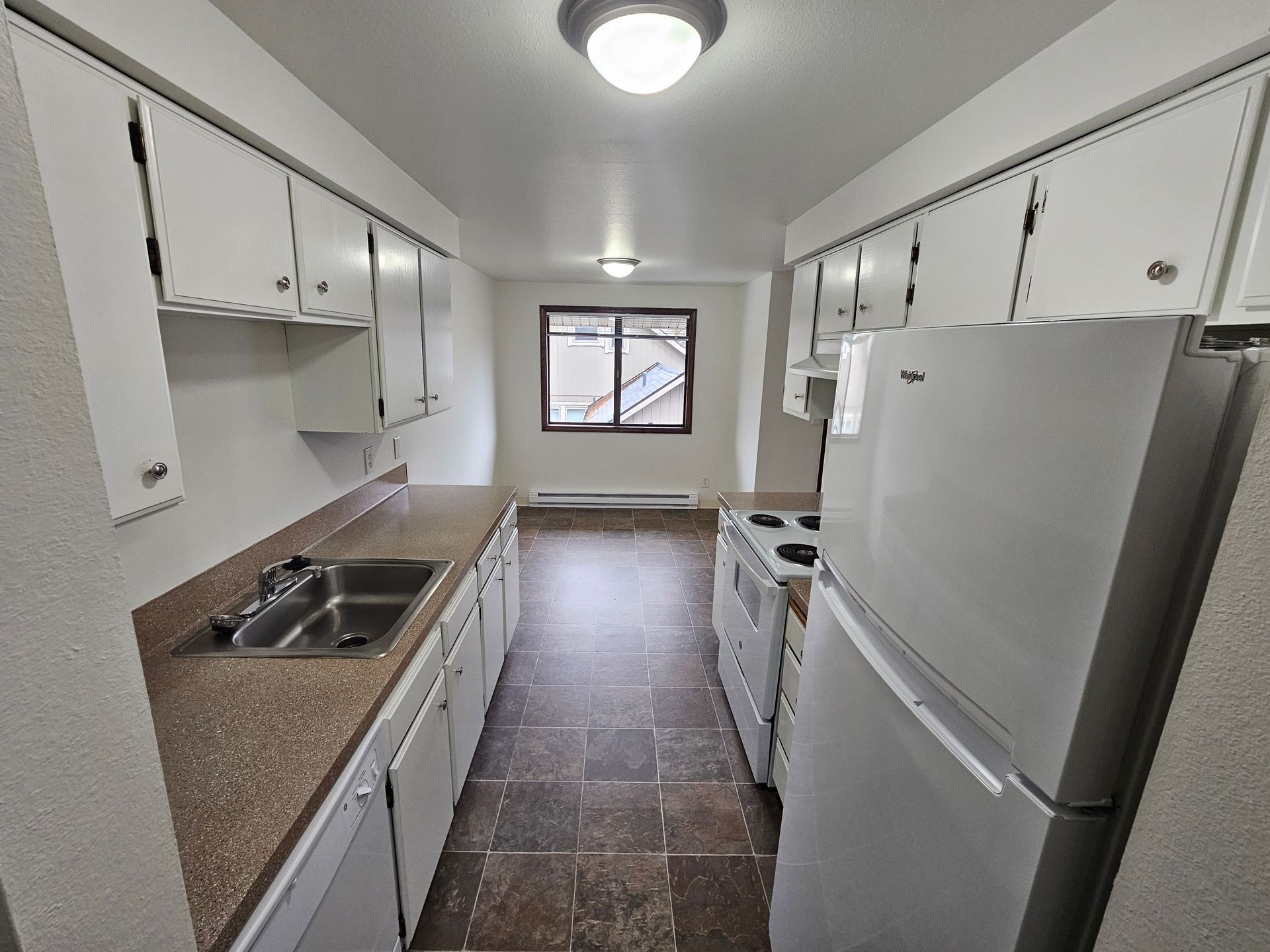 A kitchen with white cabinets and a white refrigerator