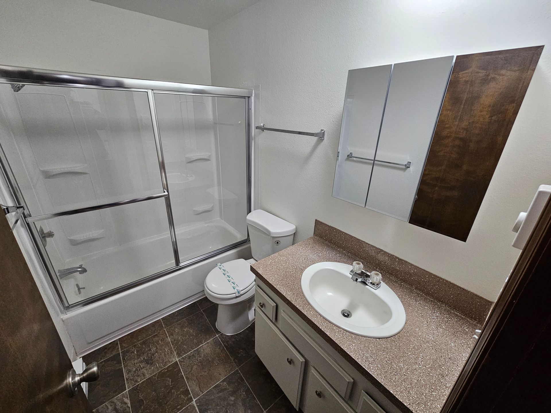 A bathroom with a toilet , sink , bathtub and shower.