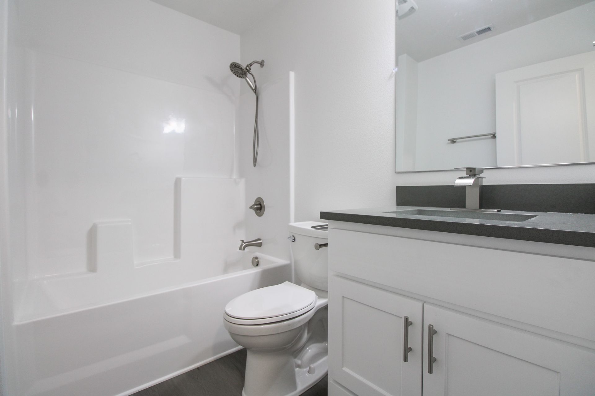 A bathroom with a toilet , sink and bathtub.