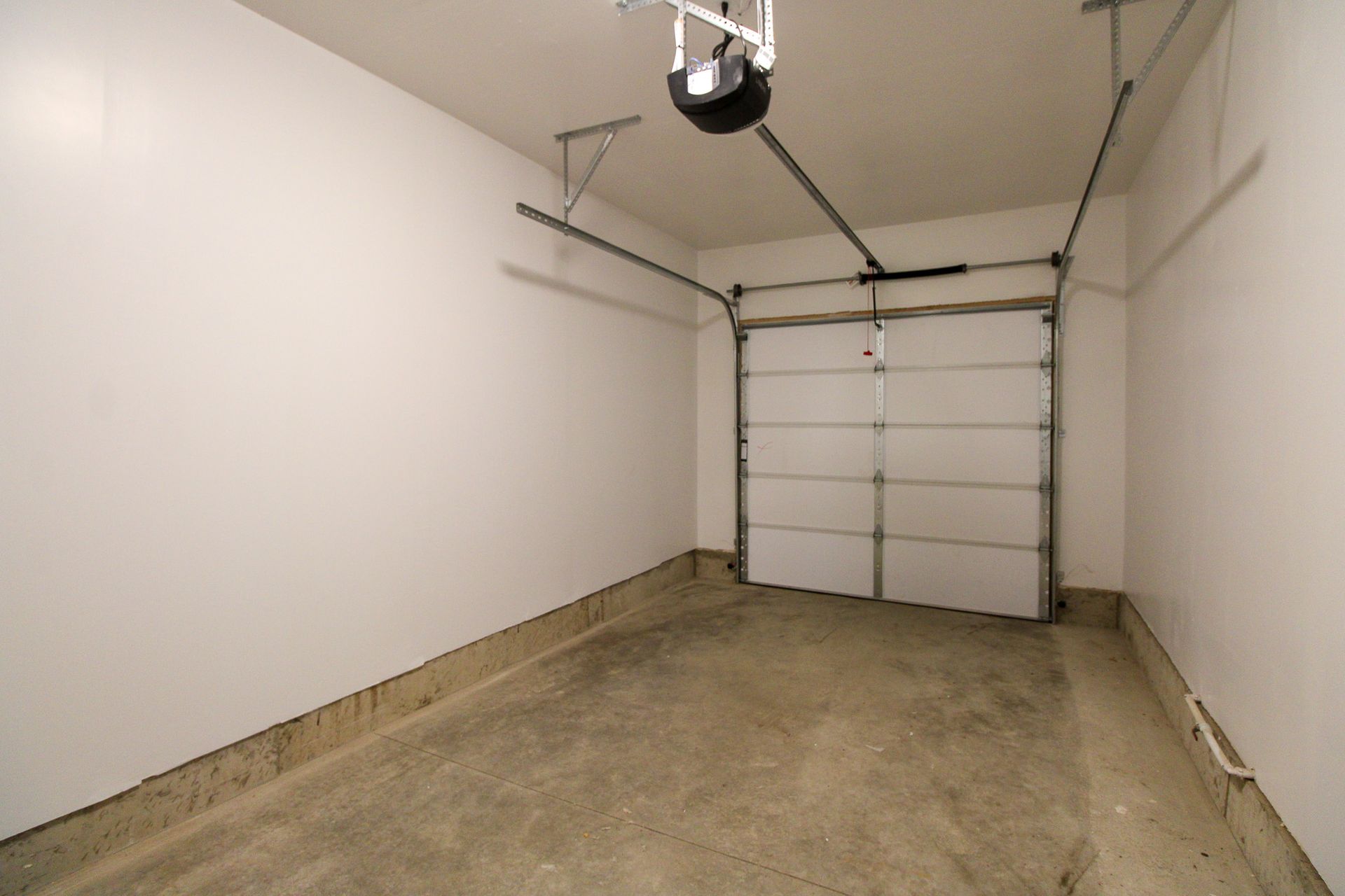 An empty garage with a garage door open