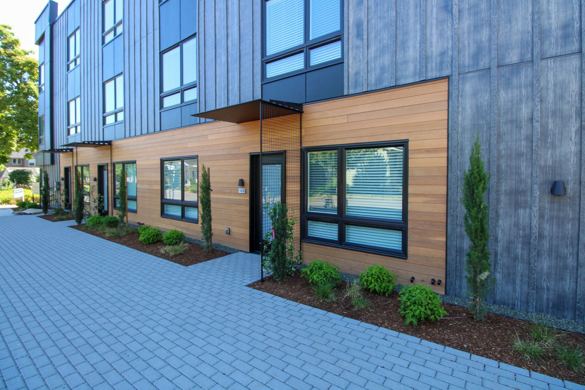 A building with a lot of windows and a brick driveway in front of it.