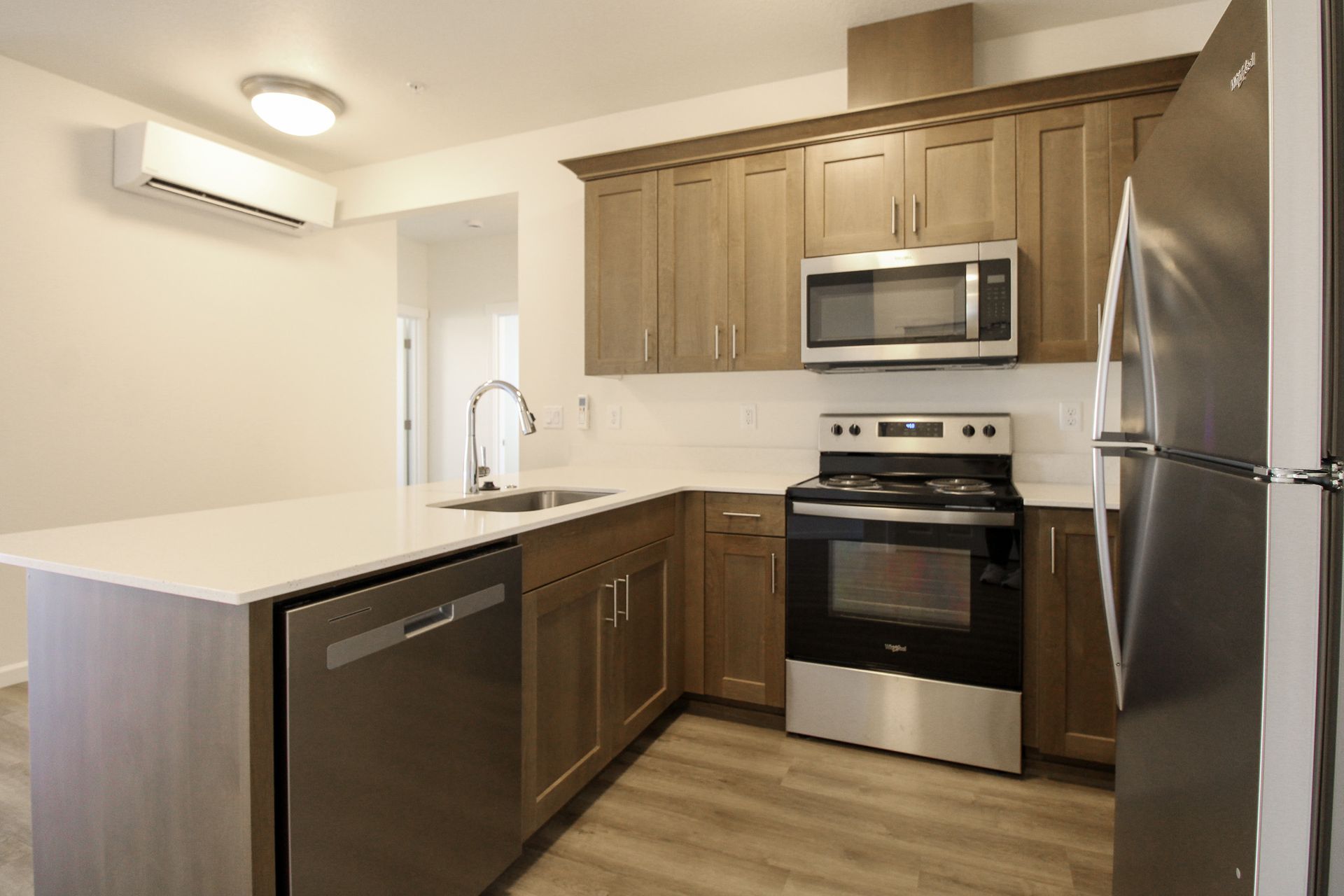 A kitchen with stainless steel appliances and wooden cabinets