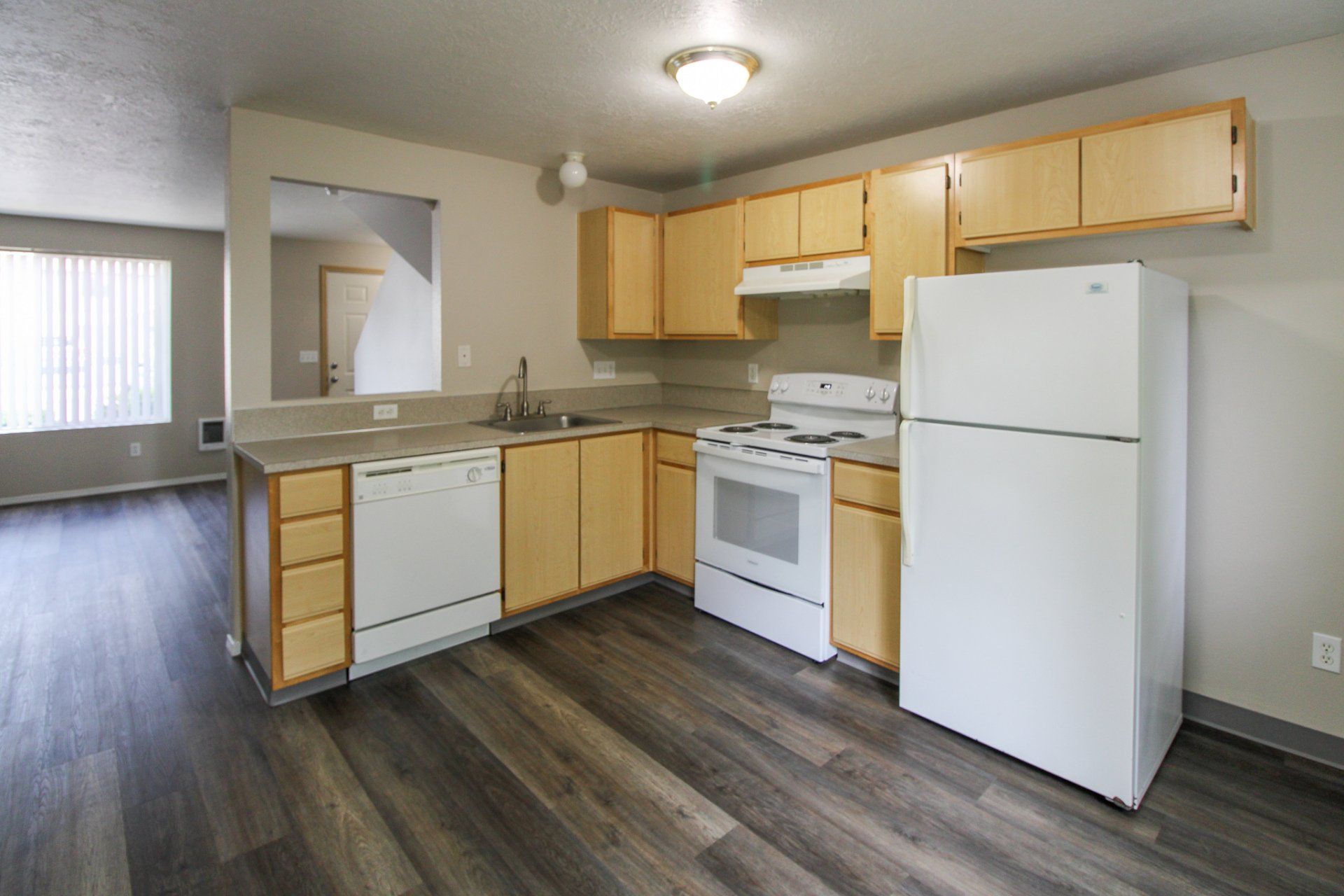 A kitchen with a refrigerator , stove , dishwasher and sink.