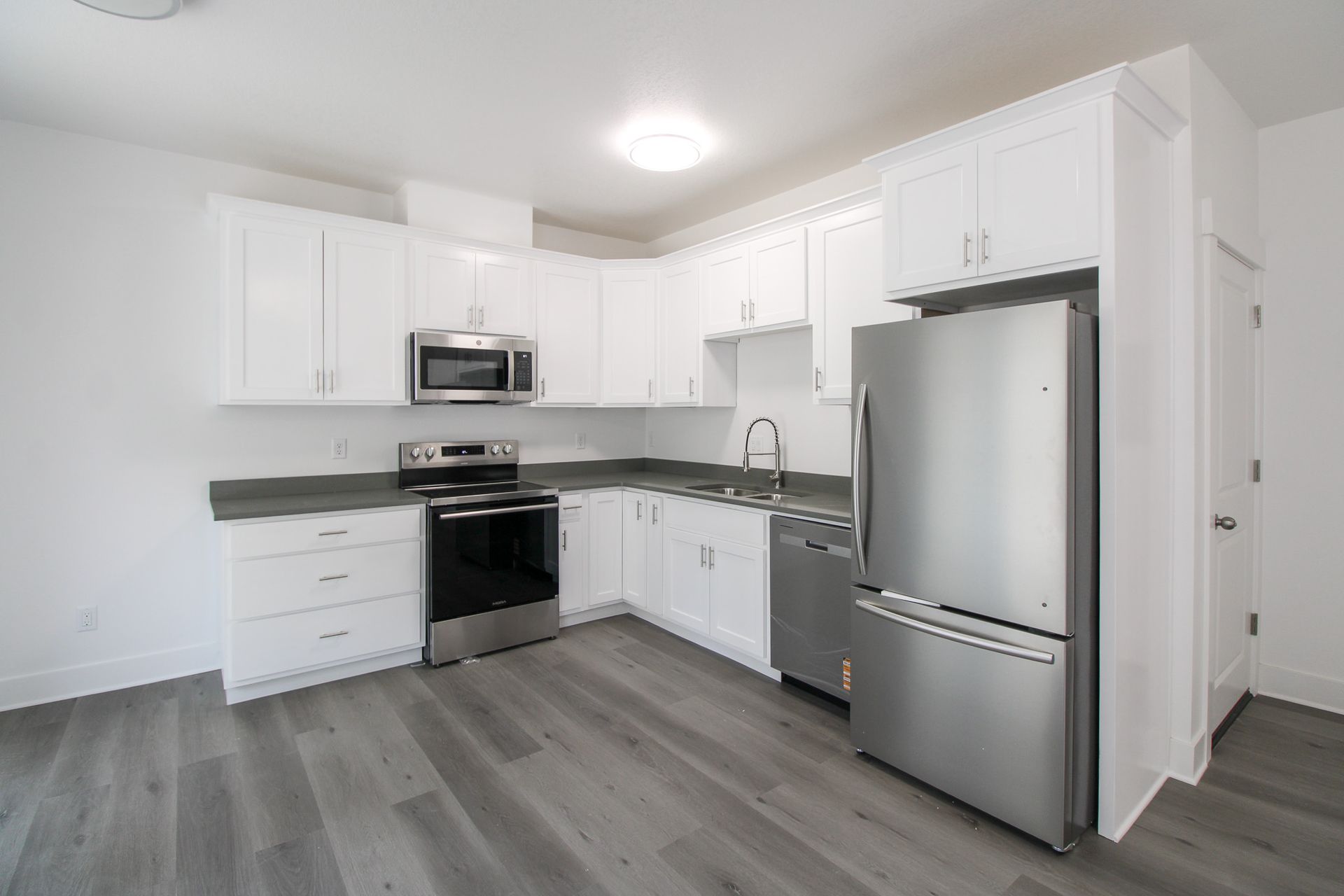 A kitchen with white cabinets and stainless steel appliances