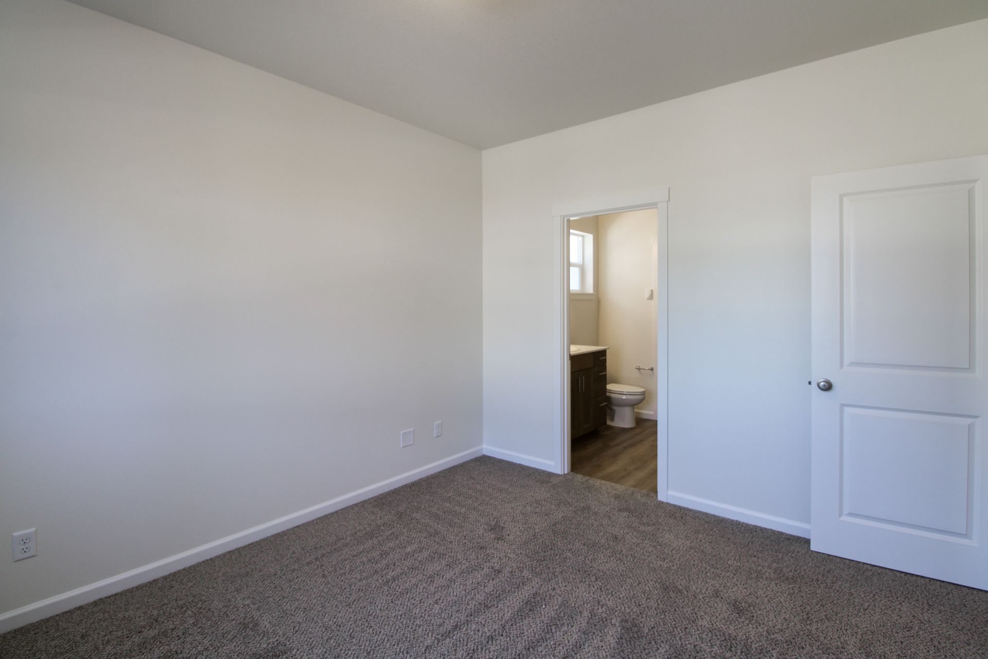 An empty bedroom with a toilet and a bathroom.