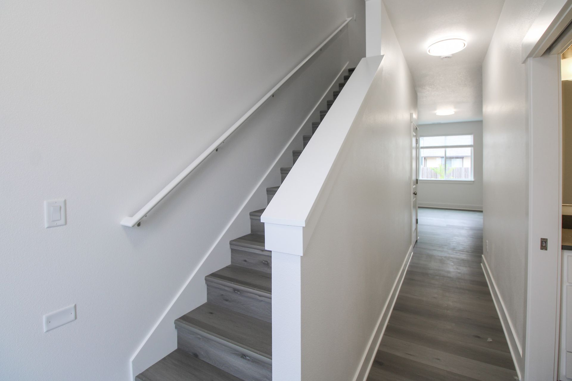 A hallway with stairs leading up to the second floor of a house.