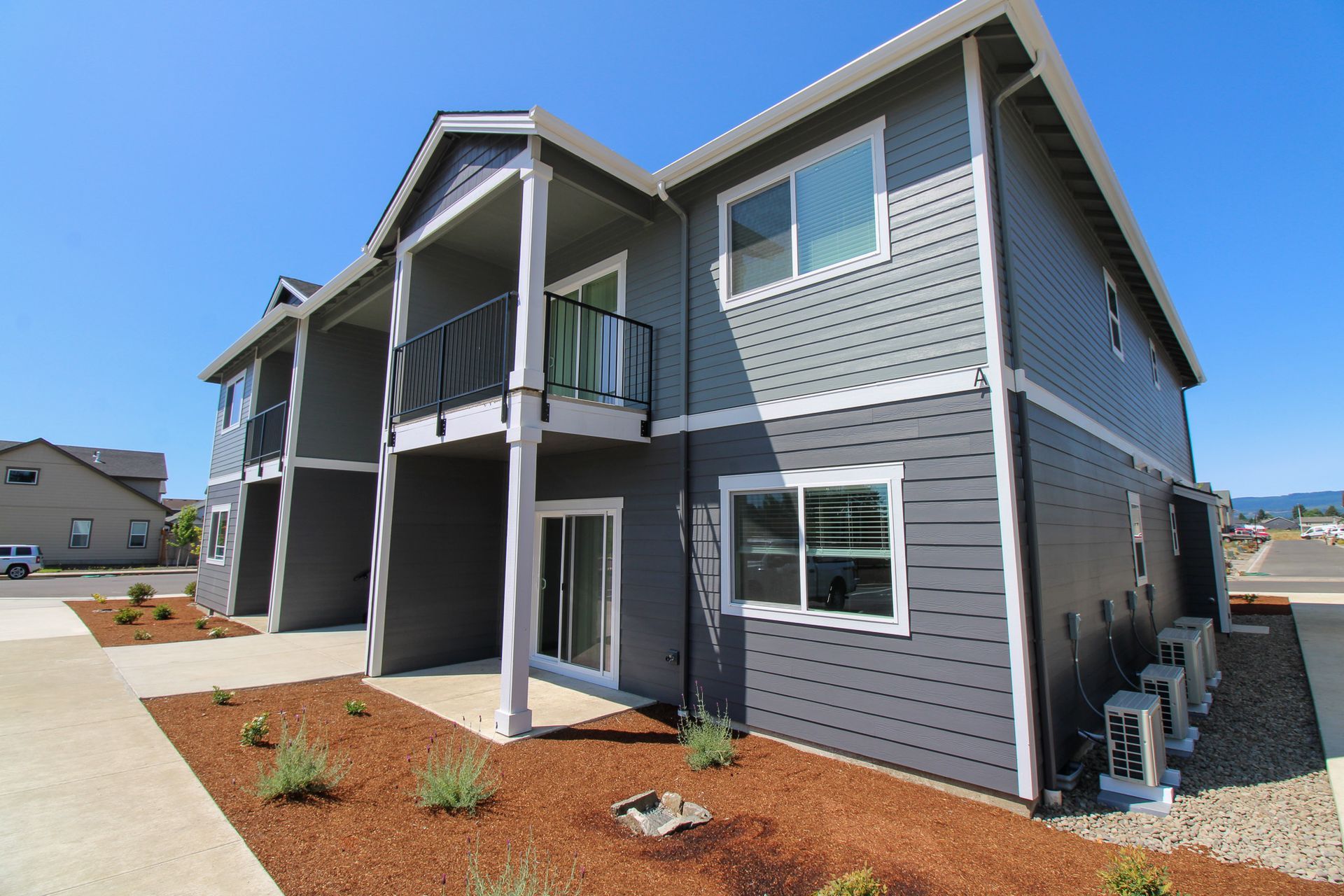 A gray house with a balcony and a lot of windows