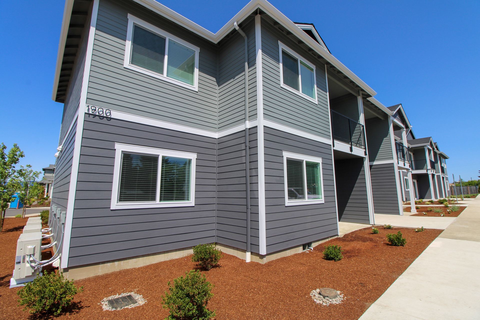 A gray apartment building with a lot of windows