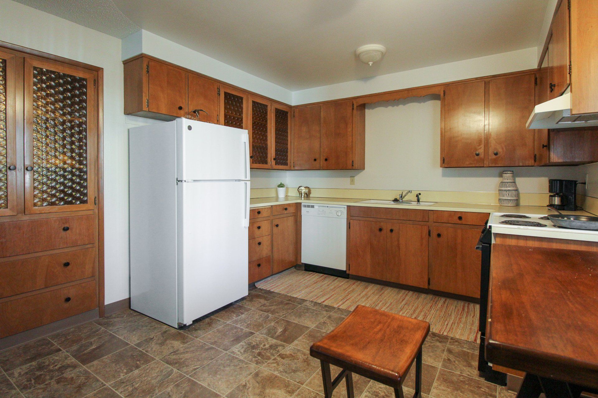 A kitchen with wooden cabinets and a white refrigerator