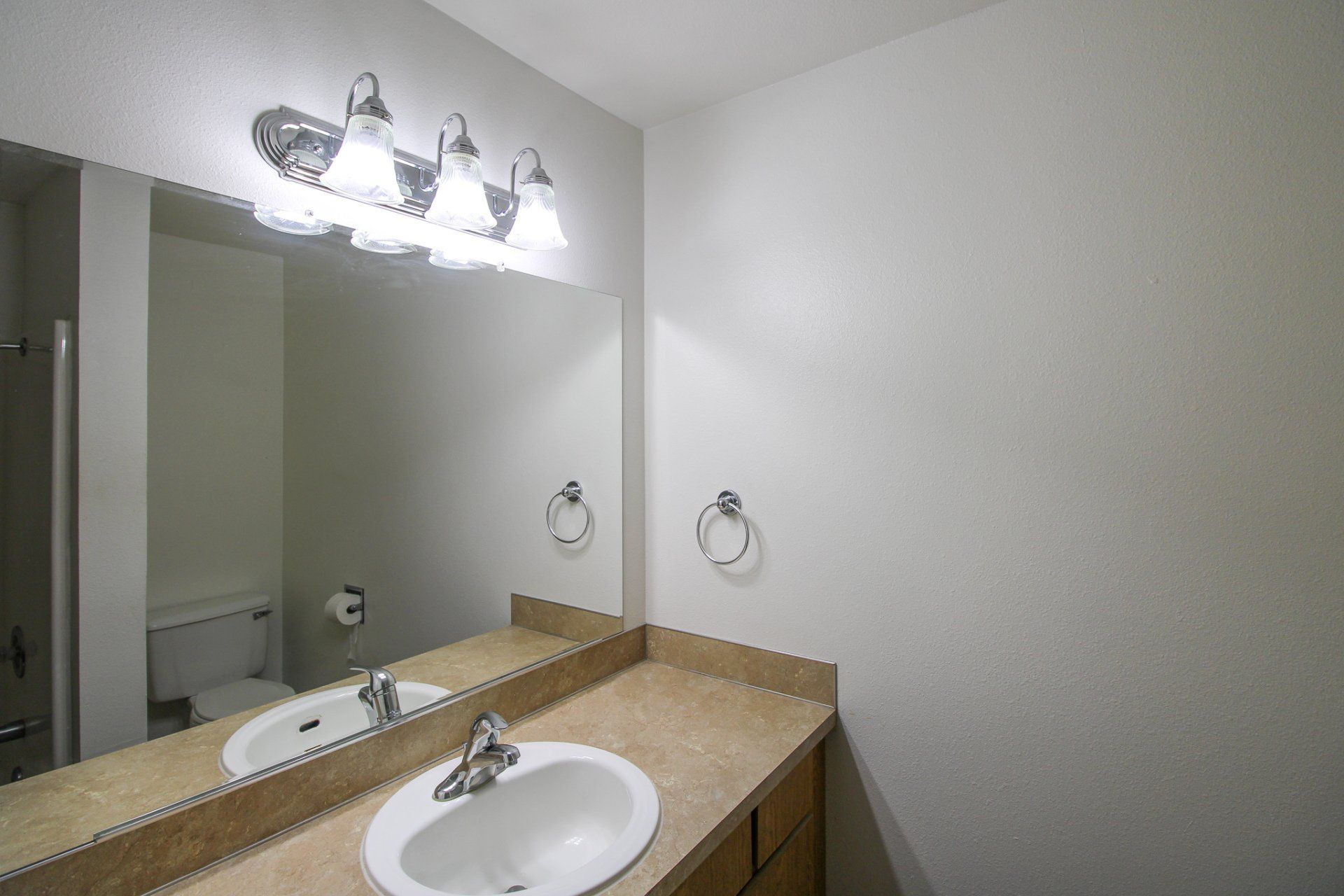 A bathroom with two sinks and a large mirror.