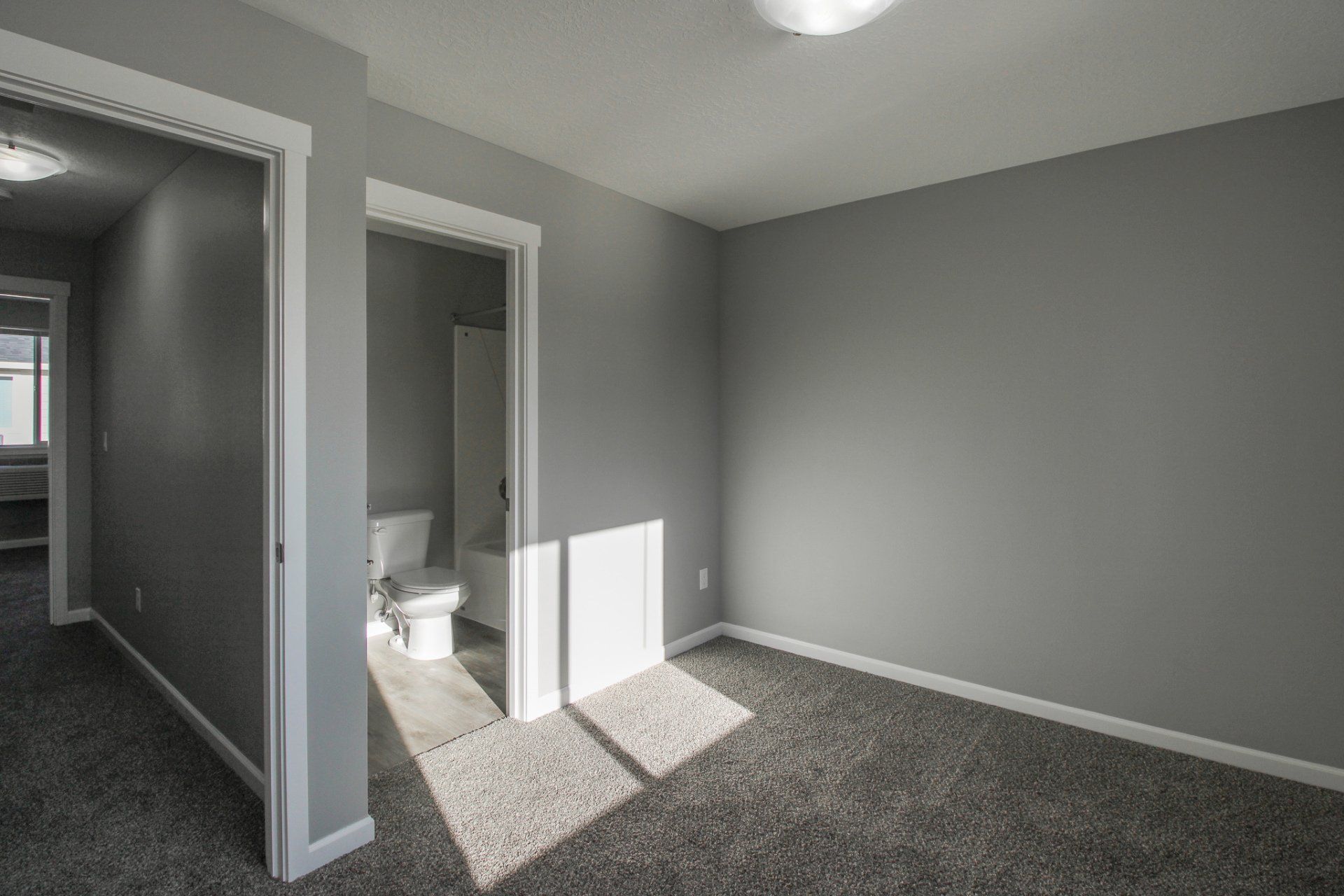 An empty bedroom with a toilet and a bathroom.