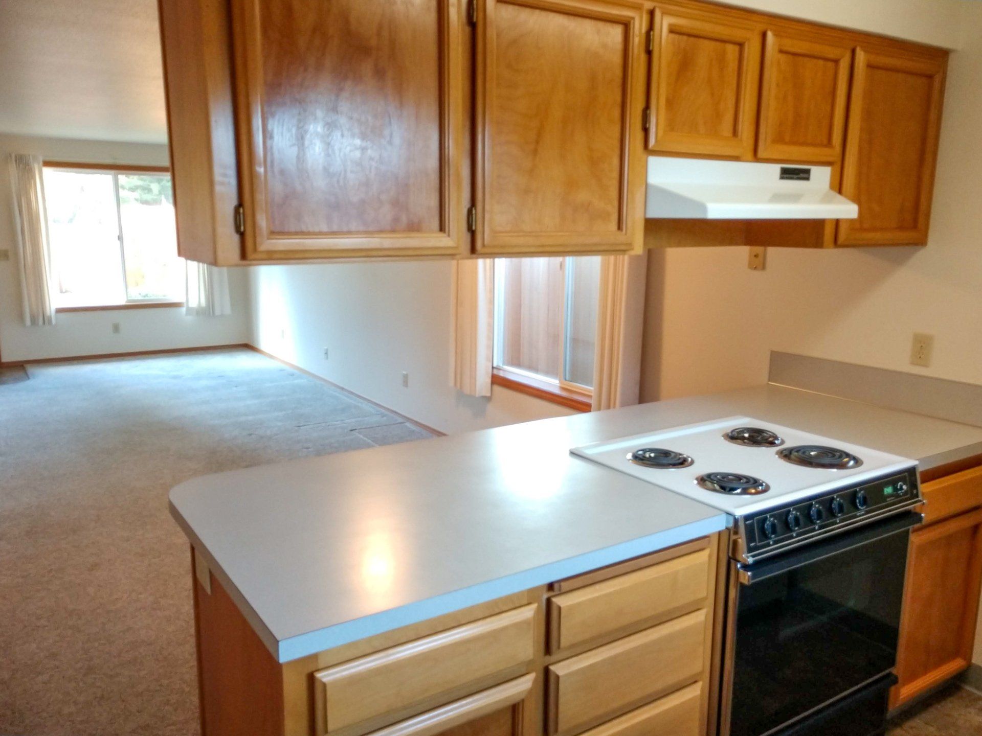 A kitchen with a stove top oven and wooden cabinets