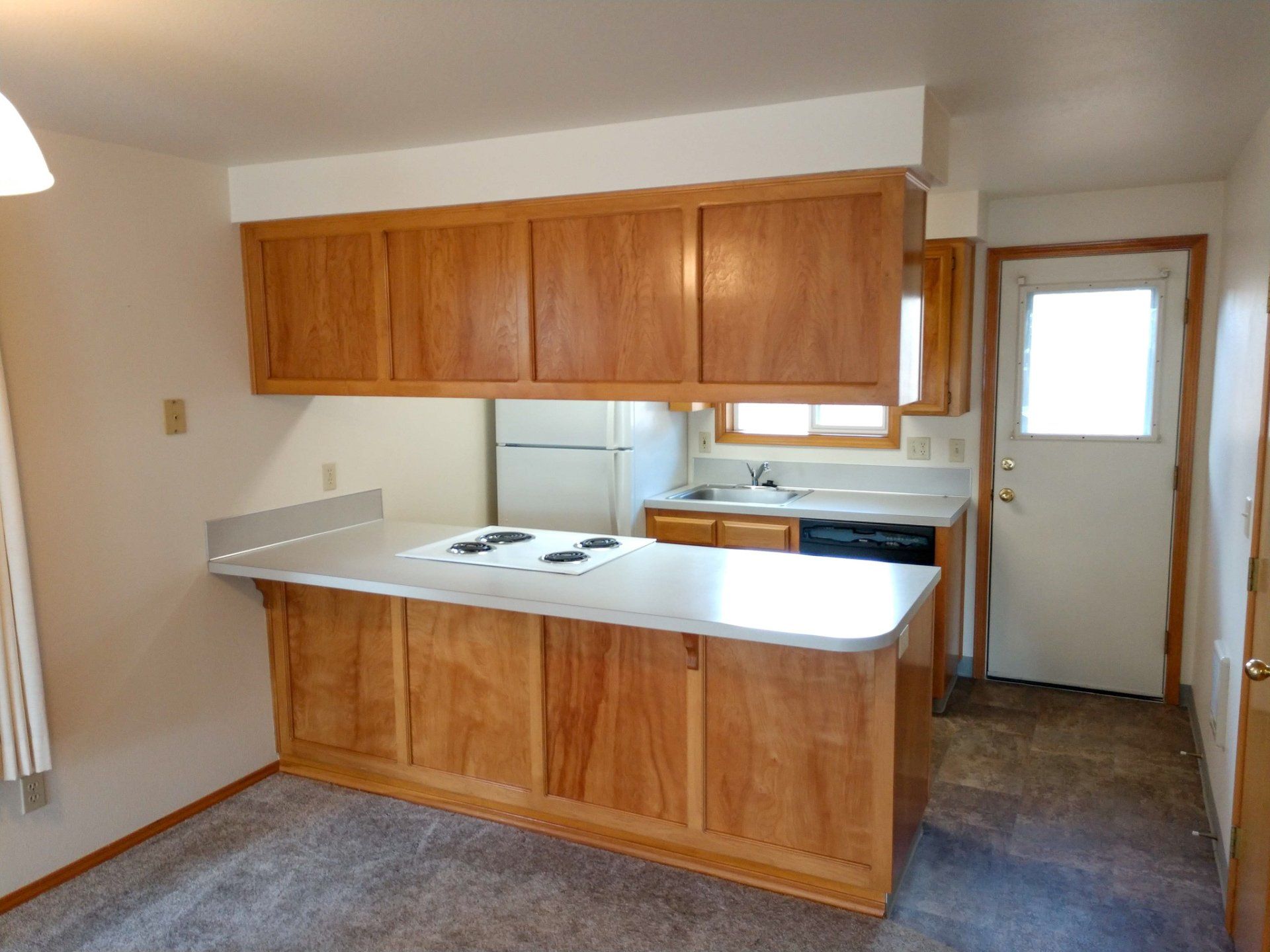 A kitchen with wooden cabinets and a white refrigerator