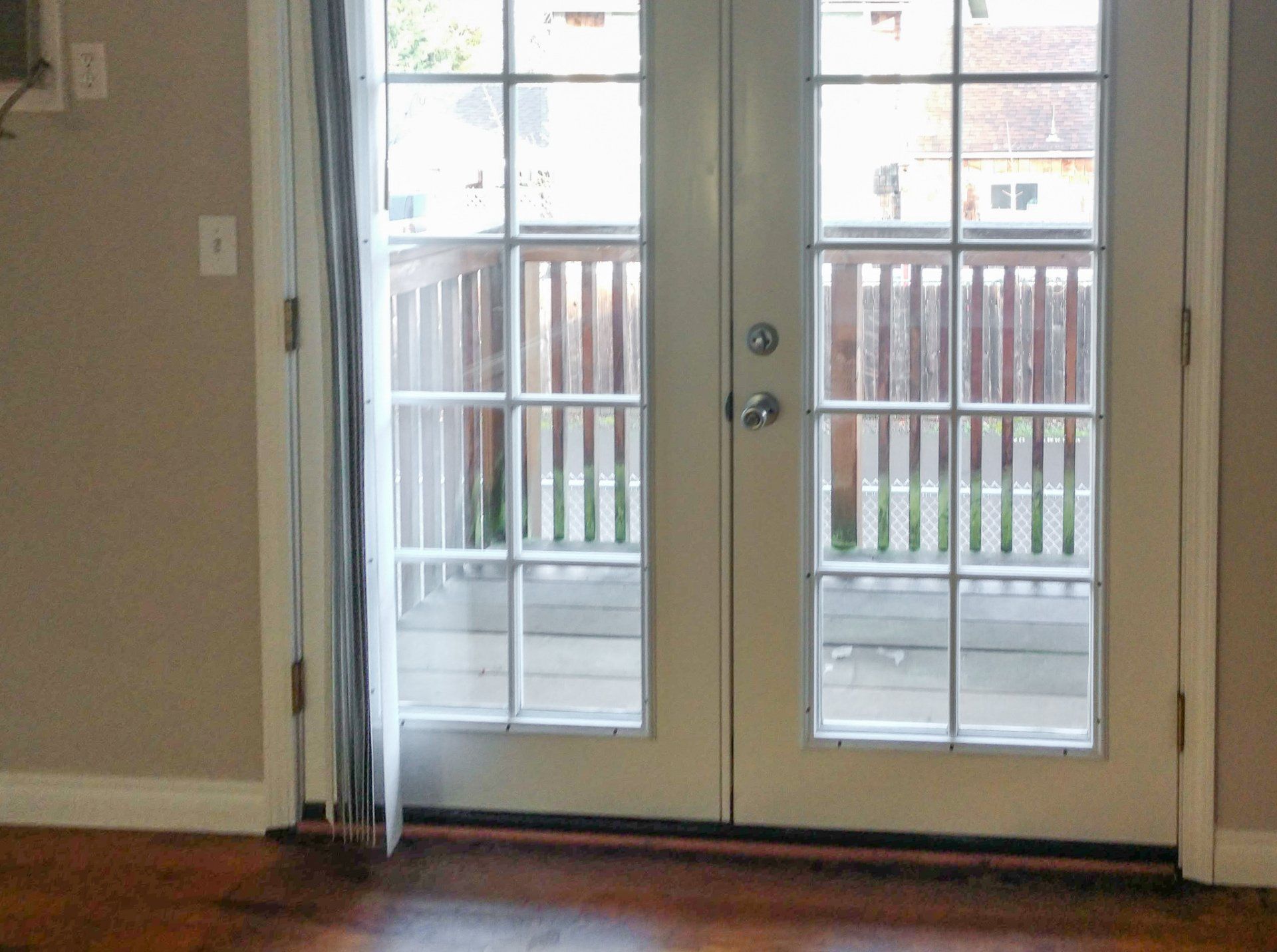 An empty room with a french door and a window.