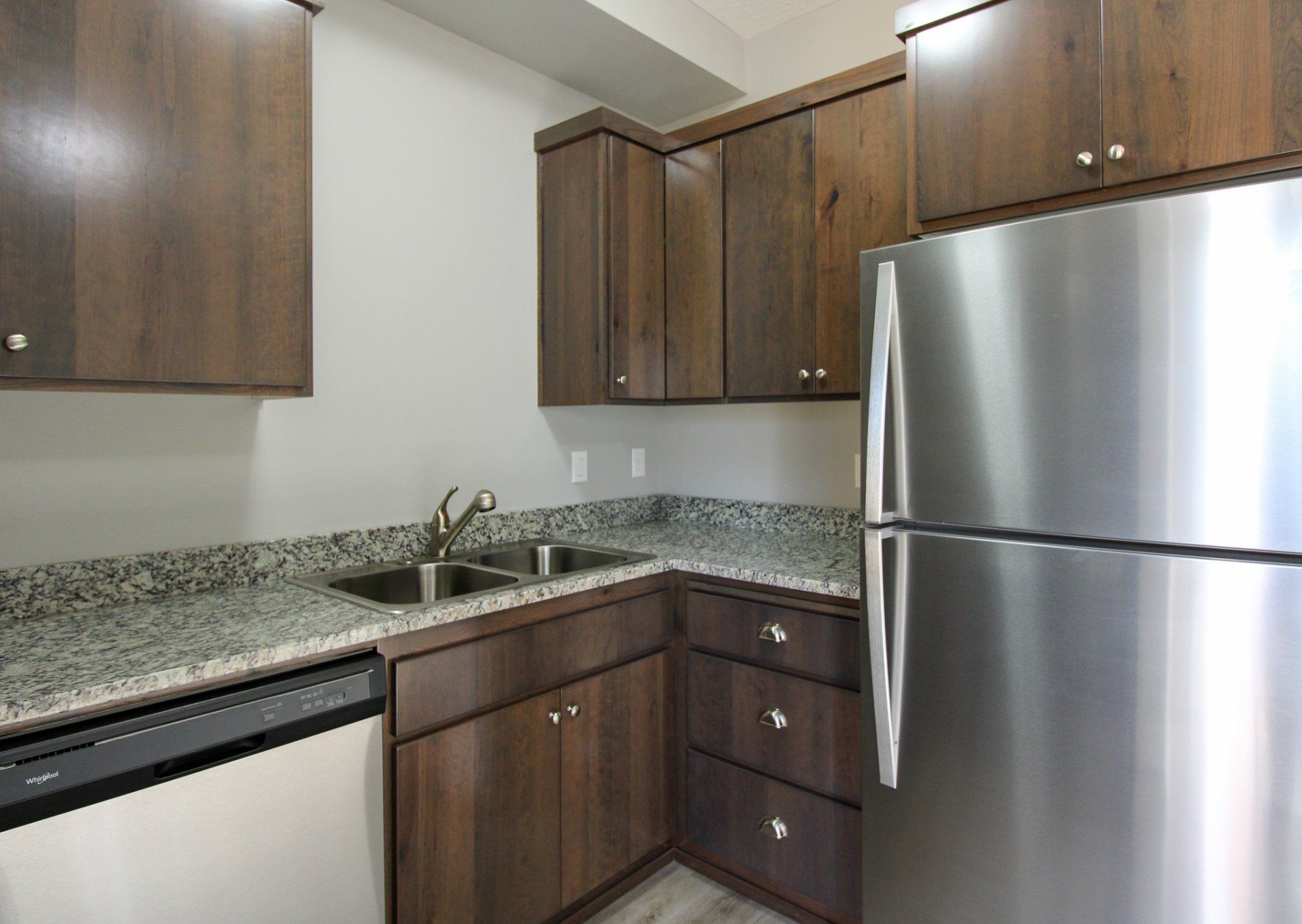 A kitchen with stainless steel appliances and wooden cabinets