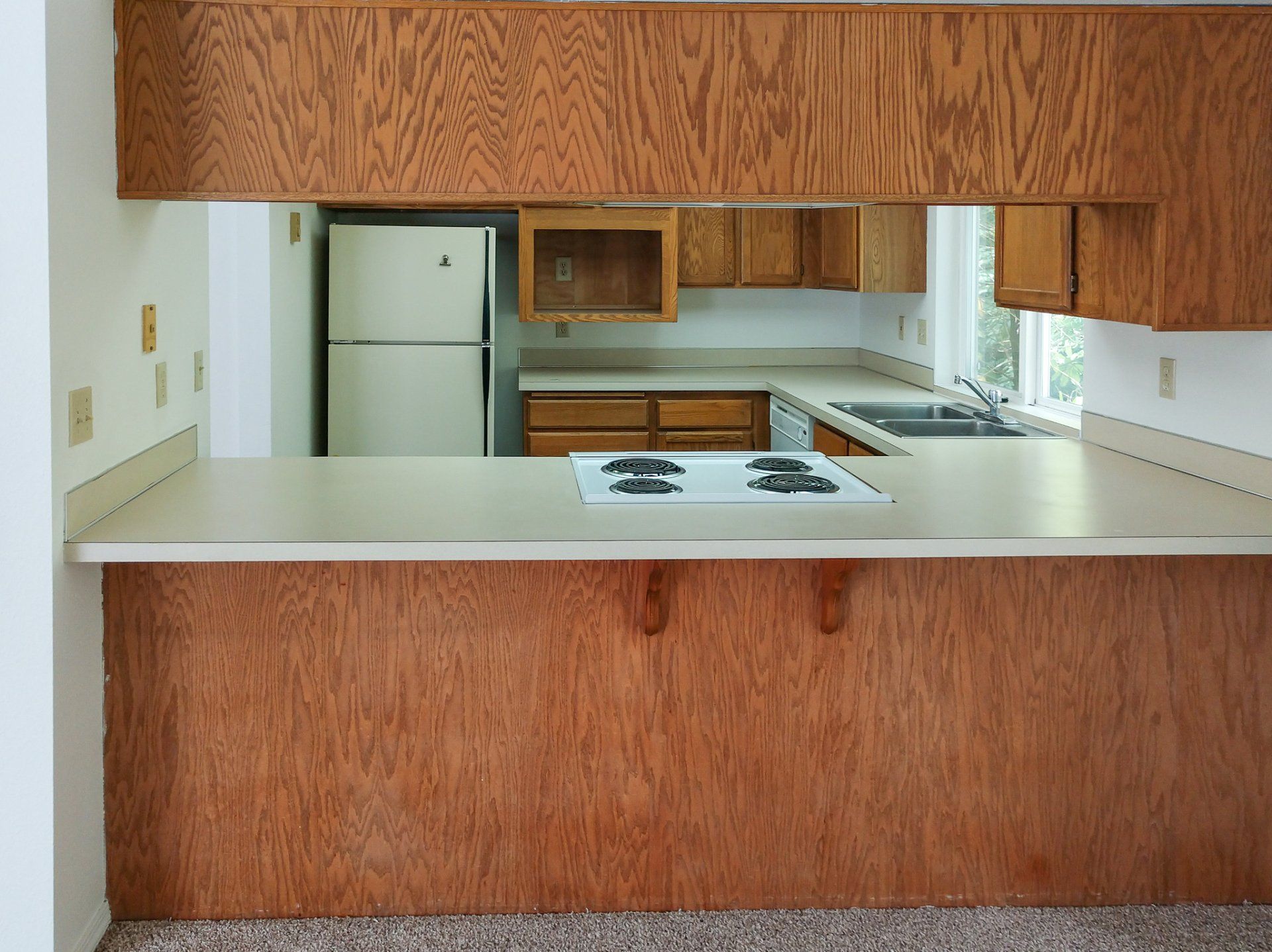 A kitchen with wooden cabinets and a white refrigerator