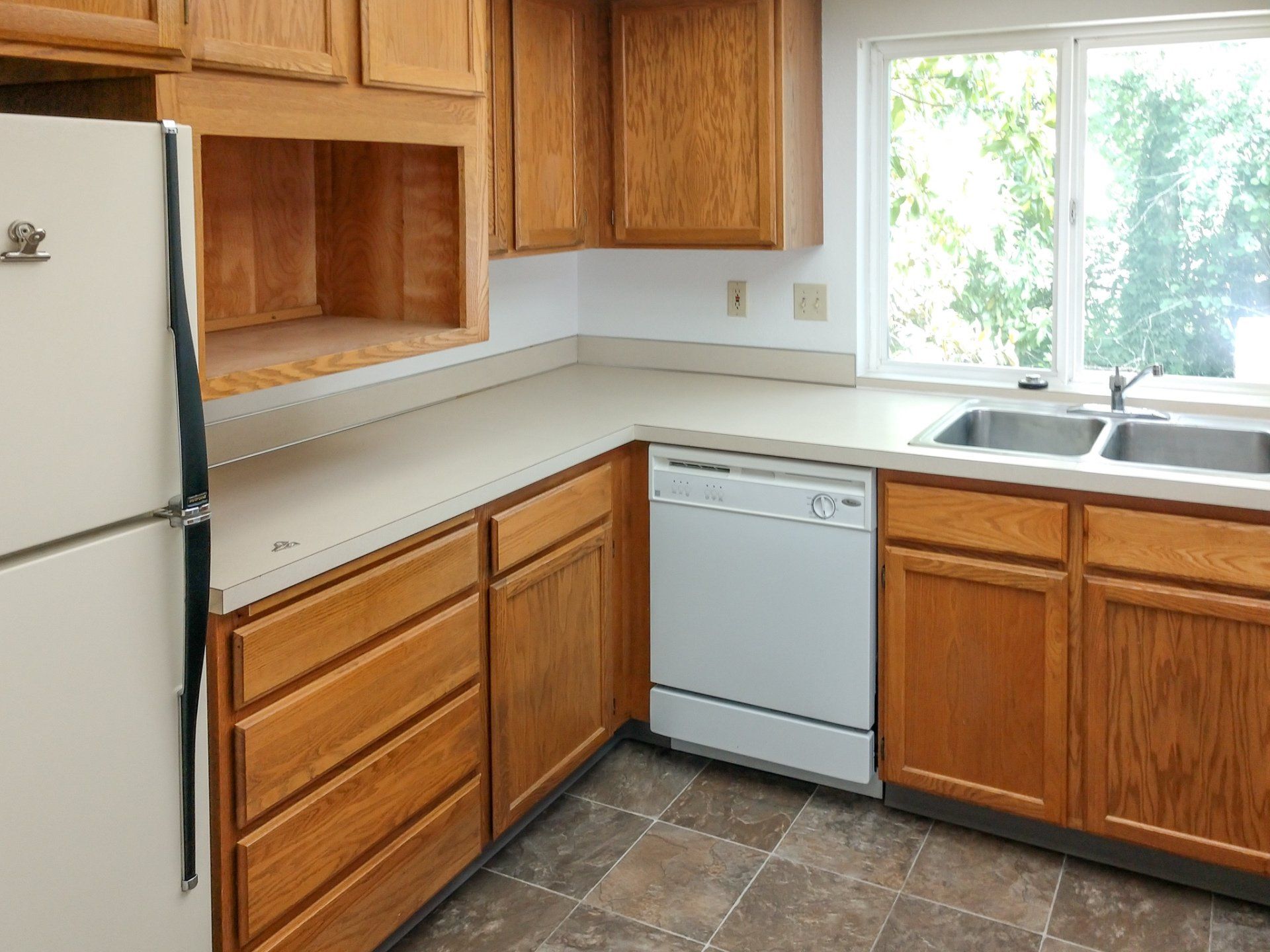 A kitchen with wooden cabinets and a white refrigerator