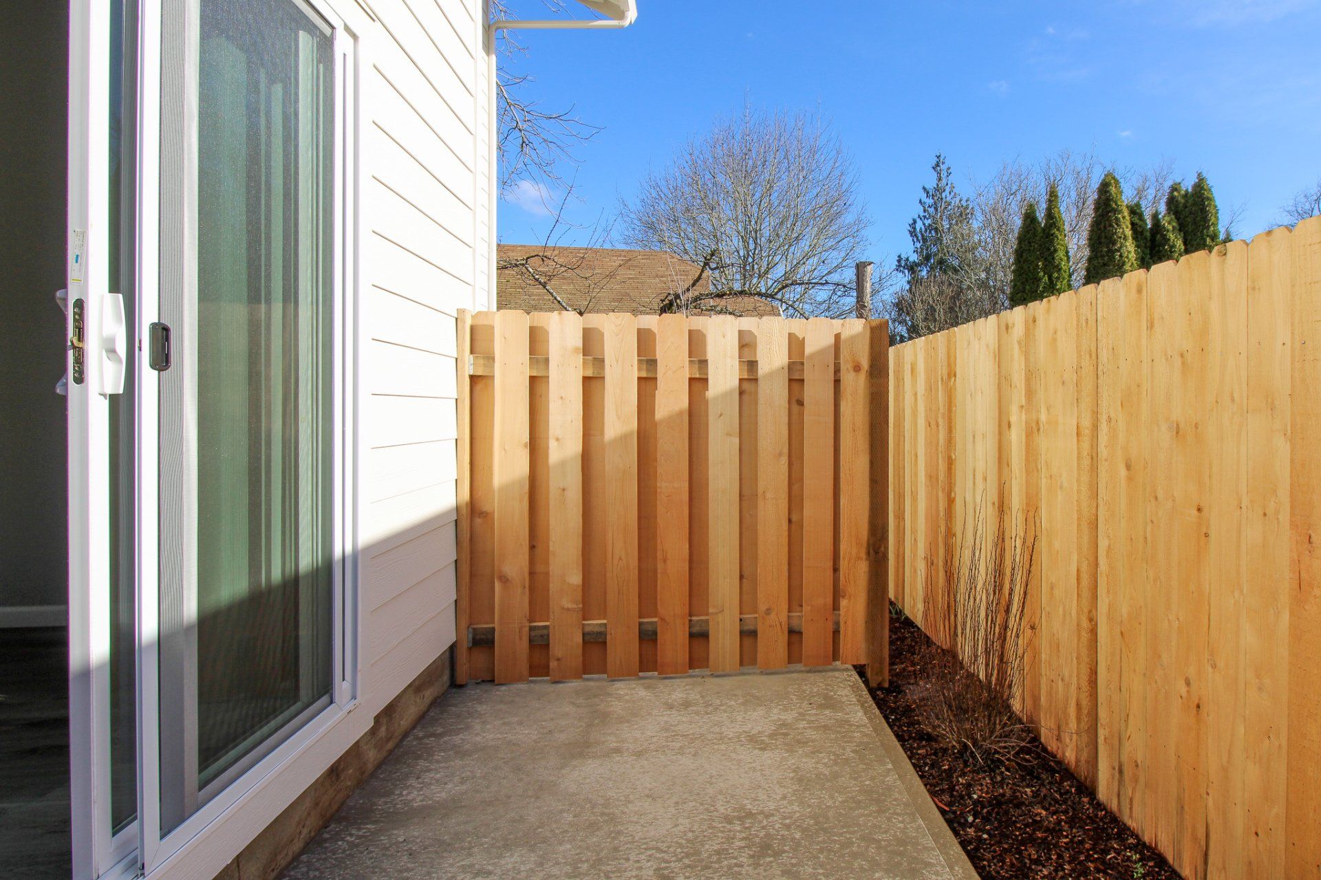 There is a wooden fence in the backyard of a house.