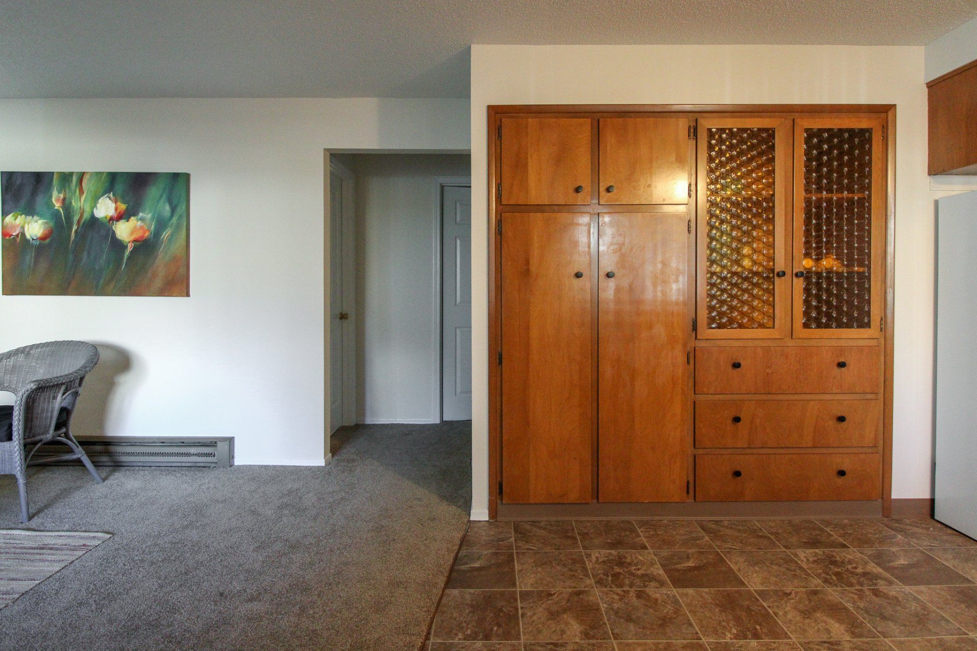 A living room with wooden cabinets and a painting on the wall