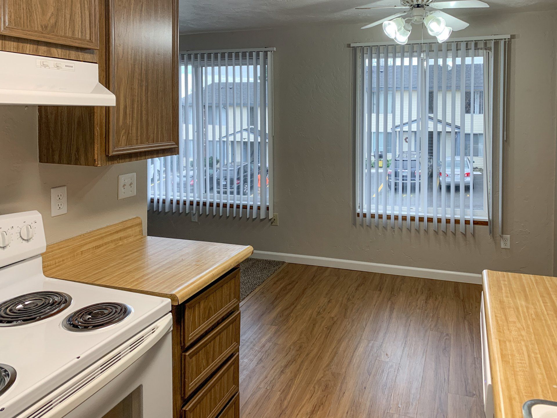 A kitchen with a stove and a window with blinds
