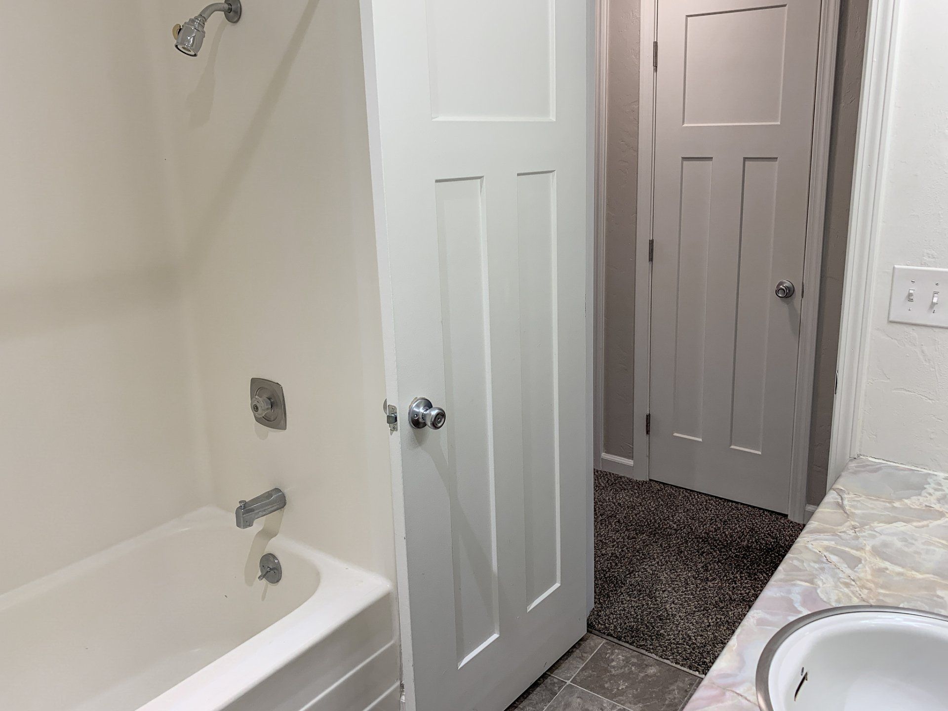 A bathroom with a tub , sink and shower.