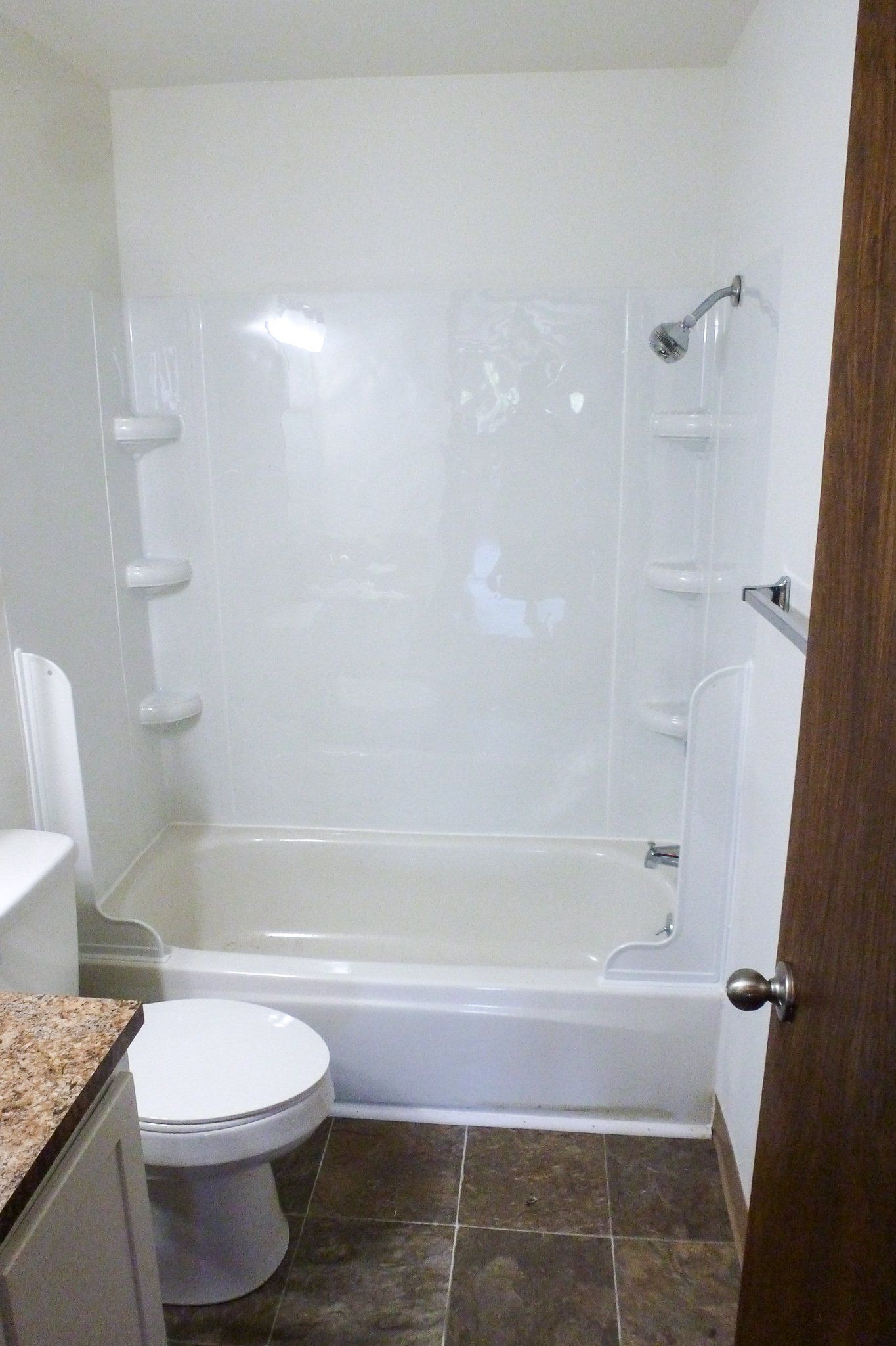 A bathroom with a toilet , bathtub and shower.