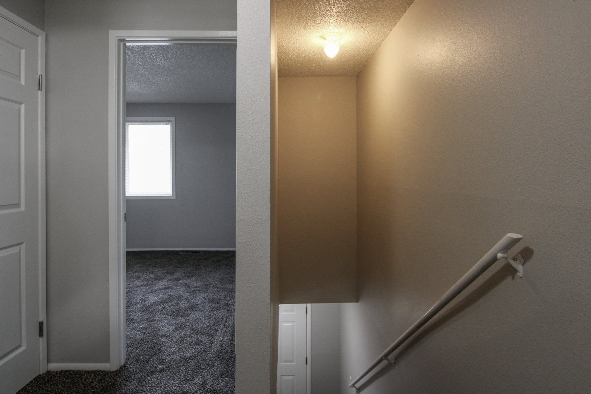 A hallway with stairs leading up to the second floor of a house.