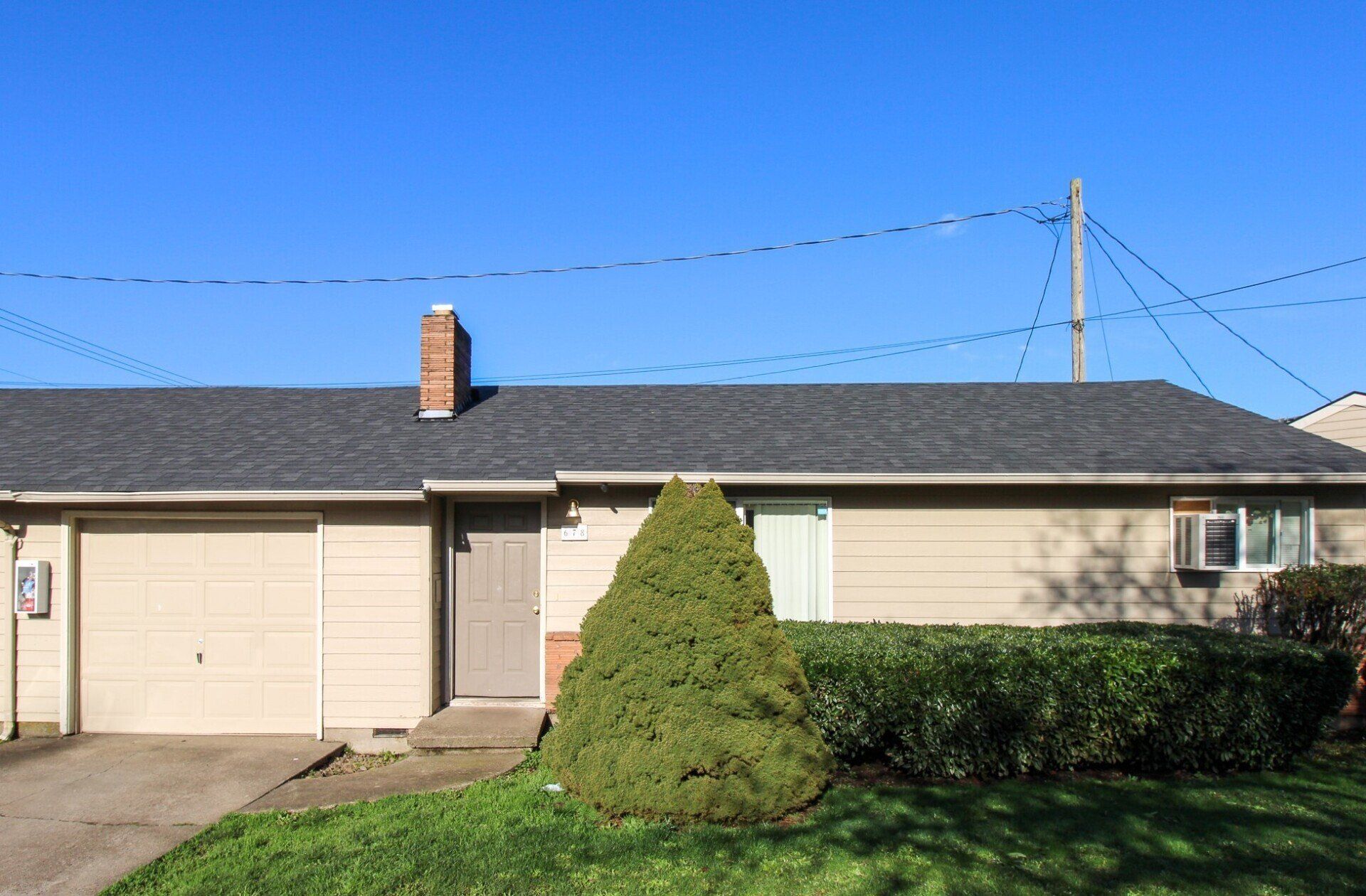 A house with a garage and a chimney on the roof.