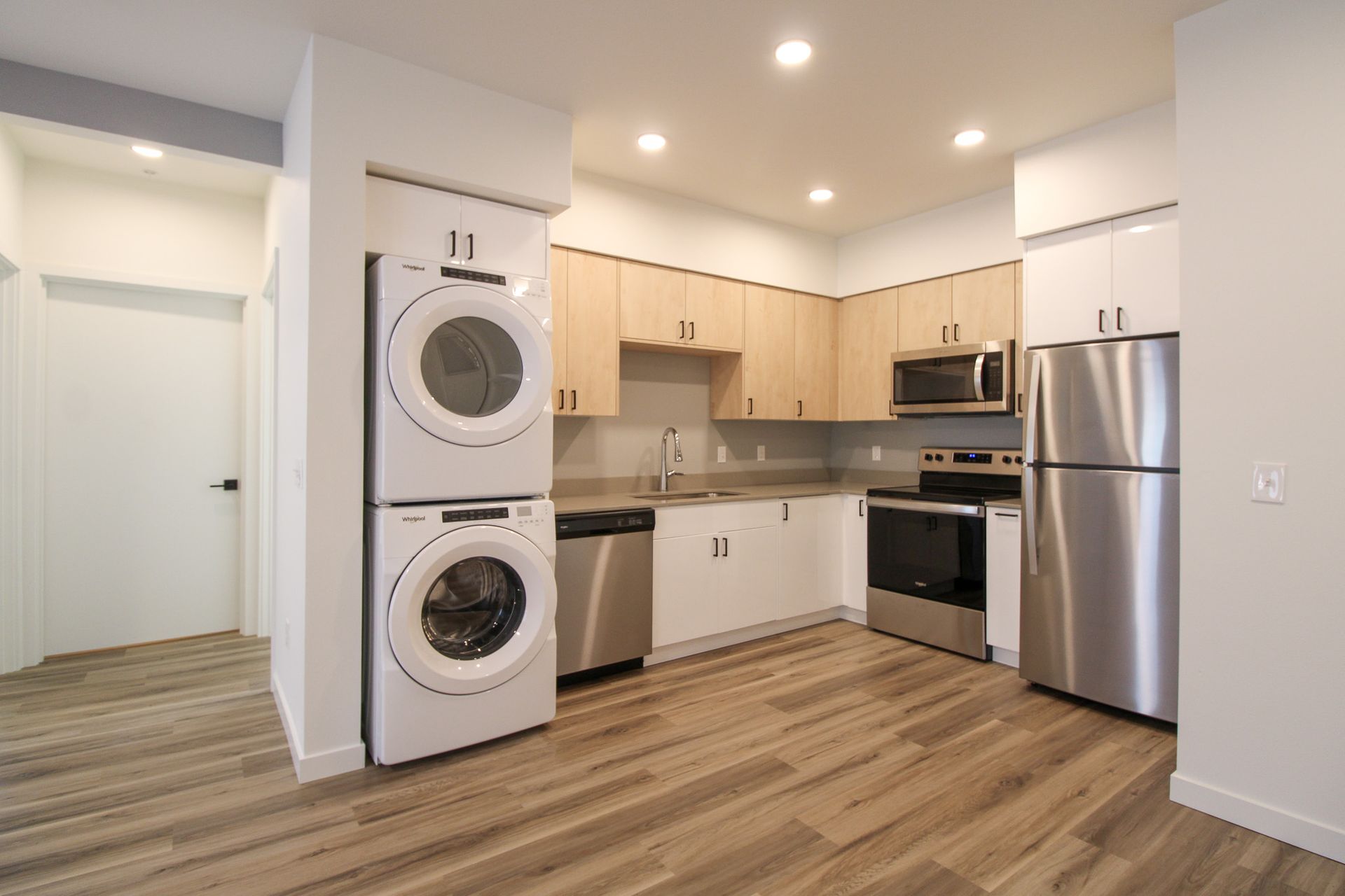 A kitchen with a washer and dryer stacked on top of each other.