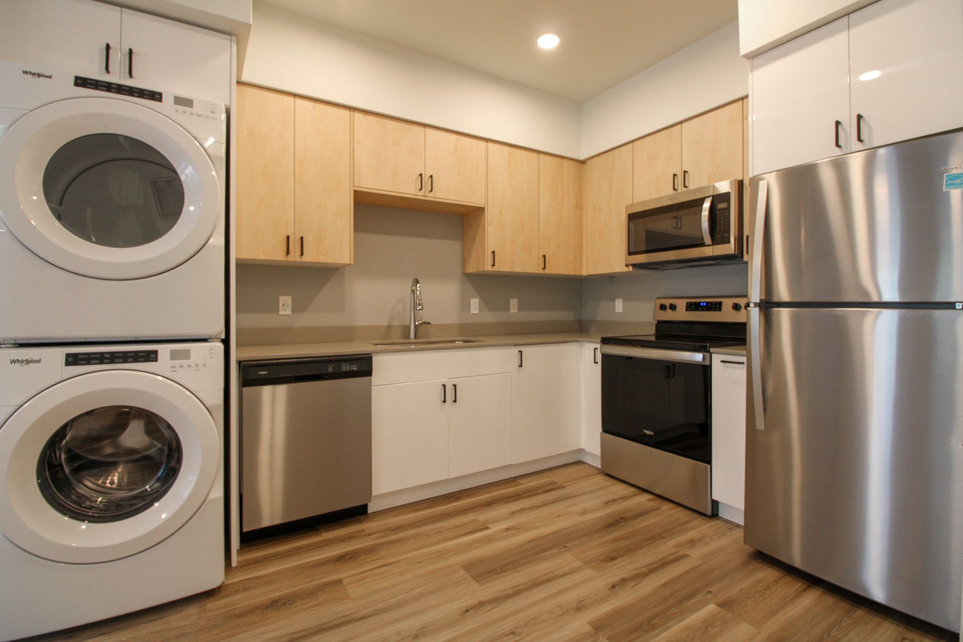 A kitchen with a washer and dryer stacked on top of each other.