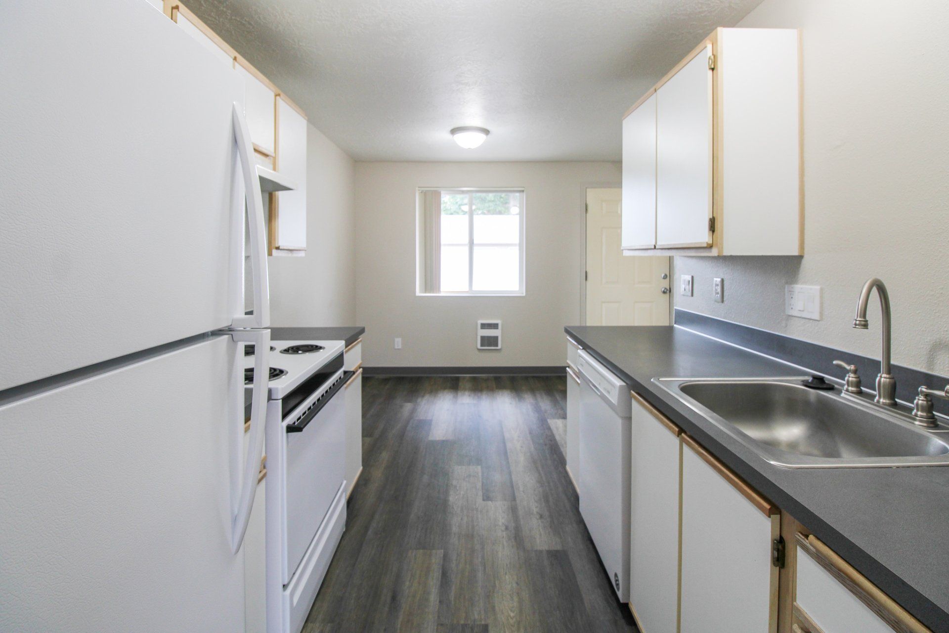 A kitchen with white cabinets and a stainless steel sink