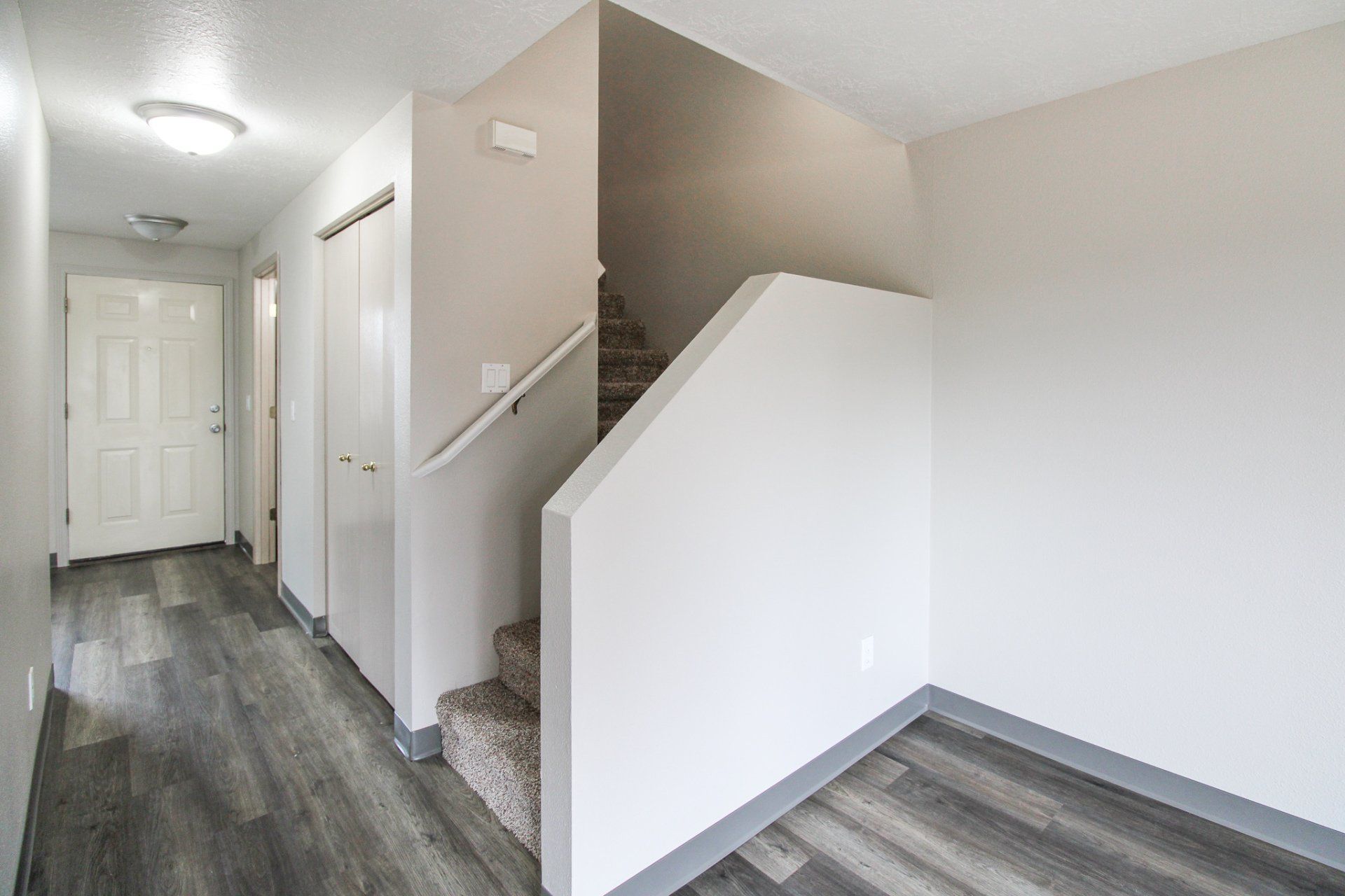 A hallway with stairs leading up to the second floor of a house.