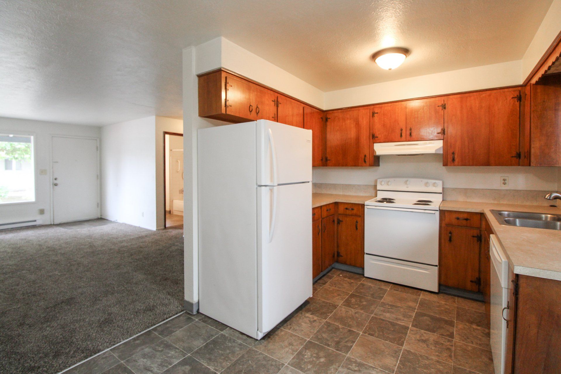 A kitchen with wooden cabinets and a white refrigerator