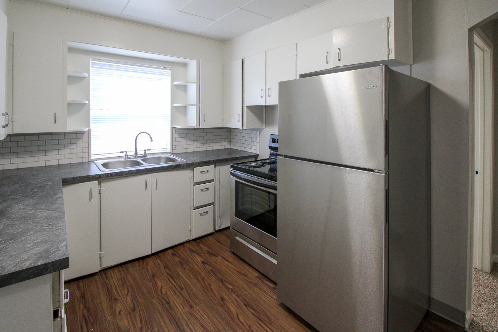 A kitchen with stainless steel appliances and white cabinets
