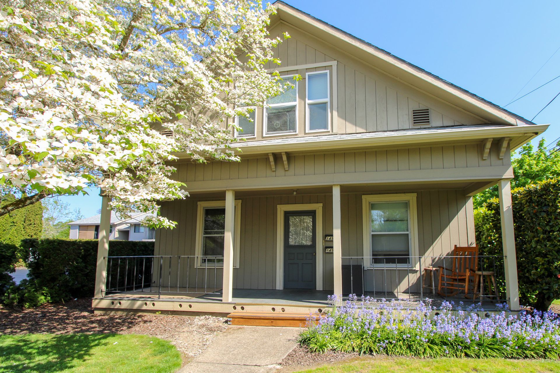A house with a porch and flowers in front of it