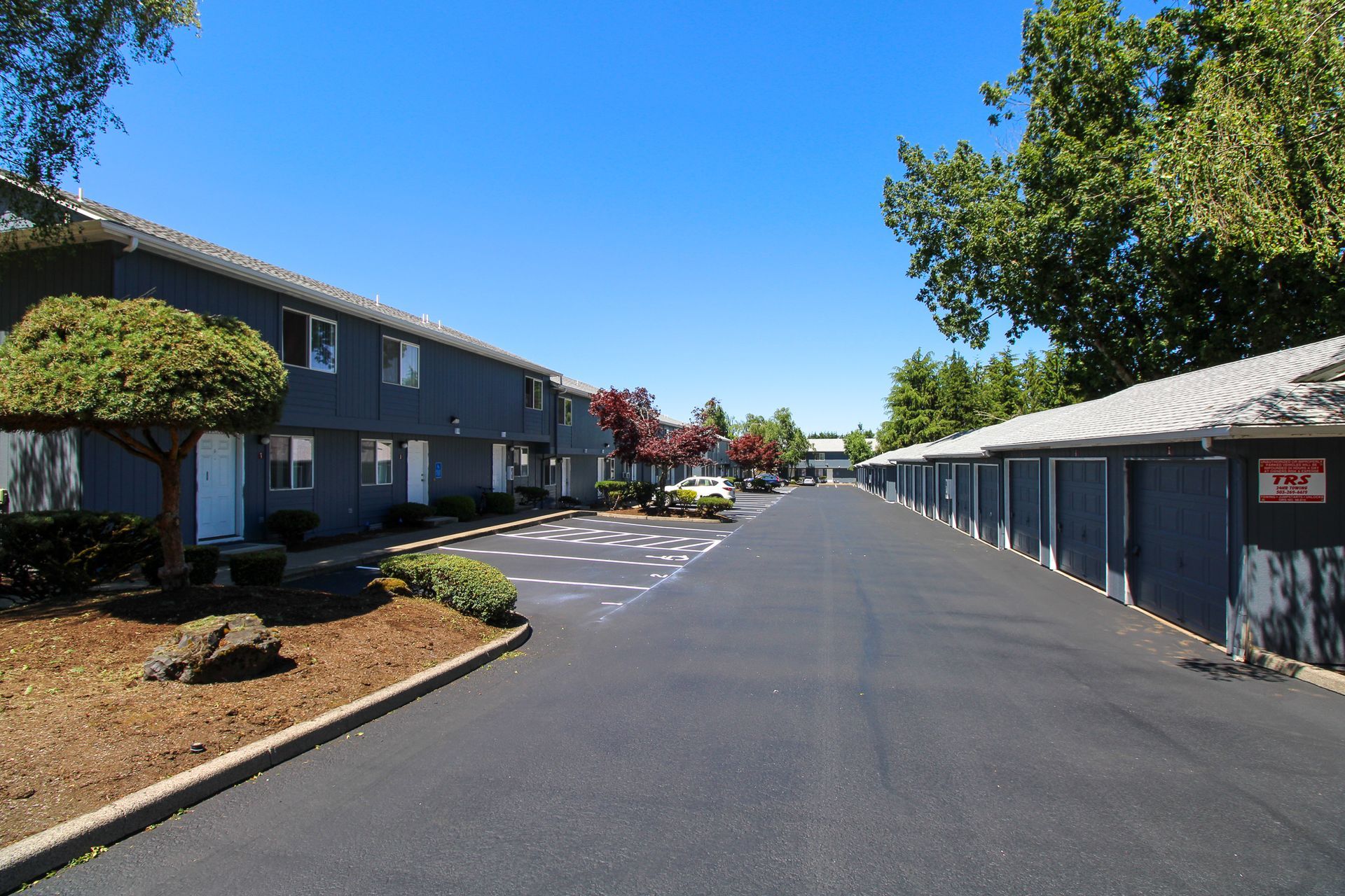 A row of apartment buildings with a parking lot in front of them