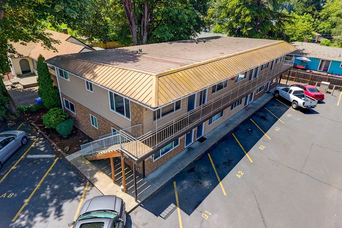 An aerial view of a building with cars parked in front of it.