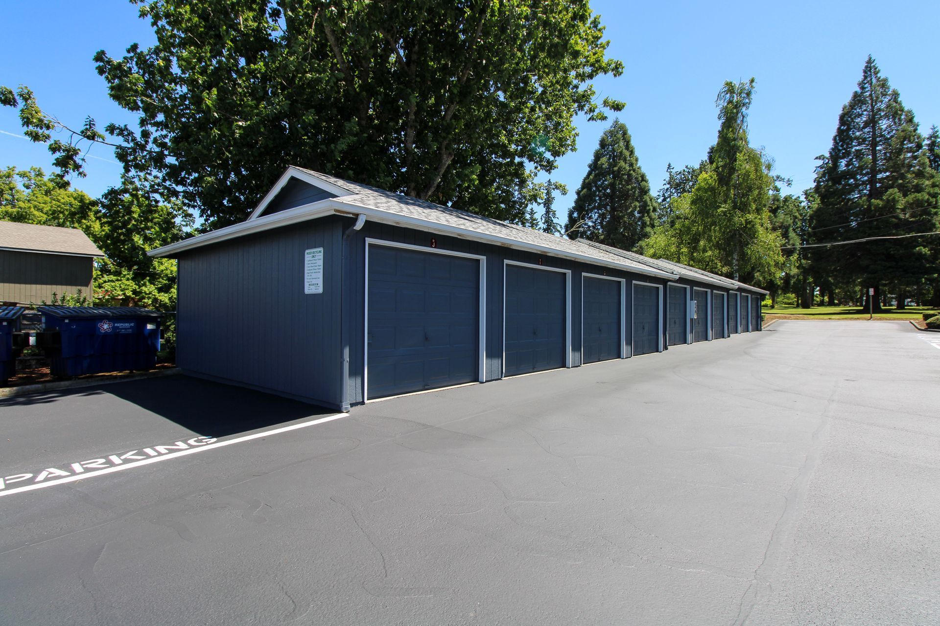 A row of garages are lined up in a parking lot