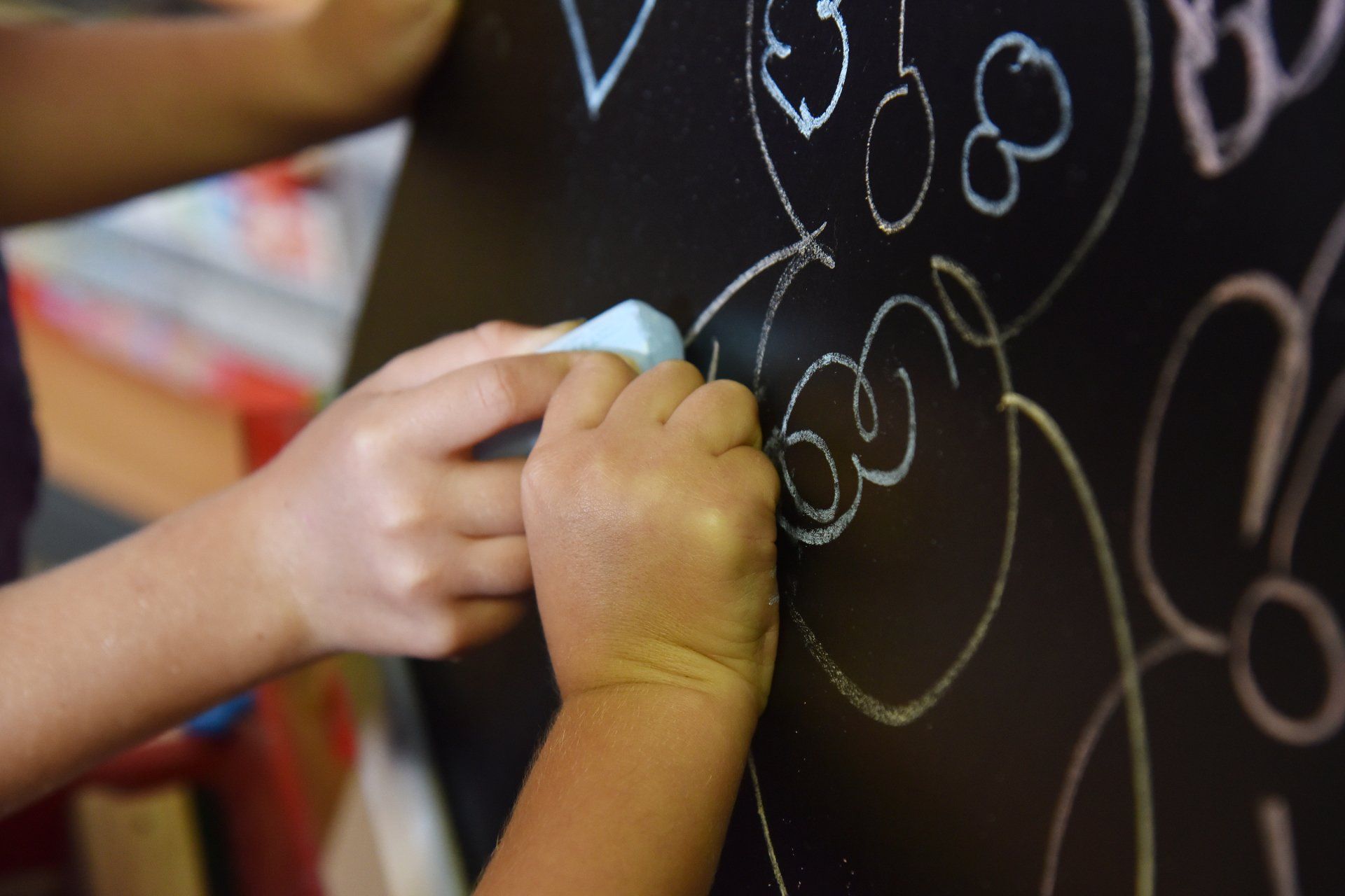 a teacher and students are swimming in a swimming pool .