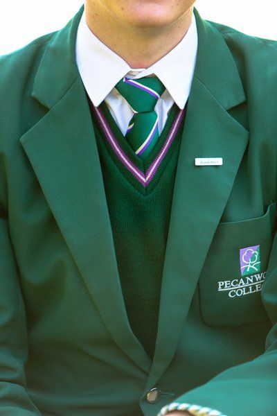 a boy is wearing a green jacket and tie from pecan college