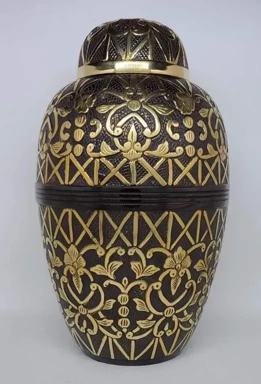 A black and gold vase with a floral design on it.