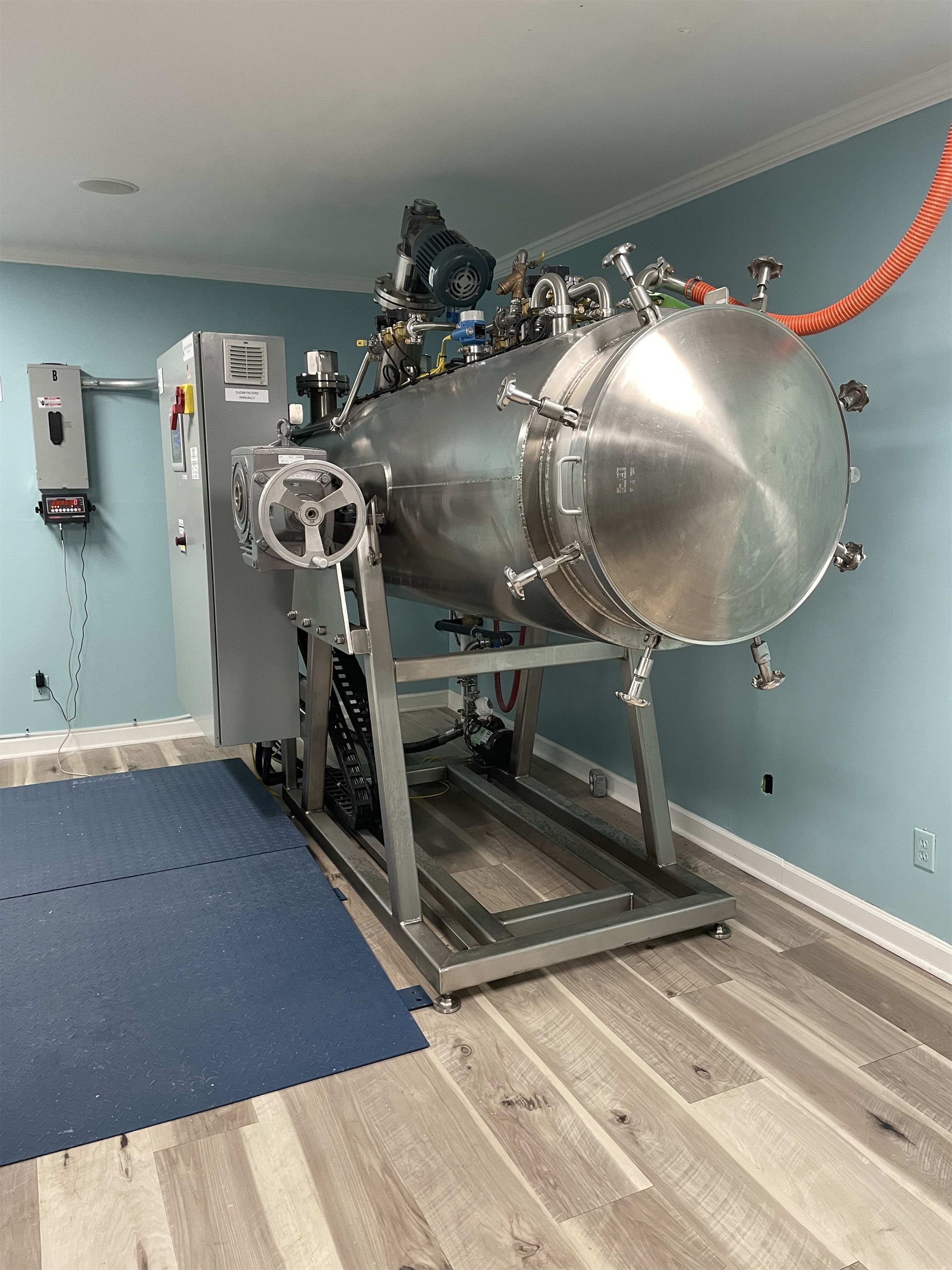 A large stainless steel tank is sitting in a room.
